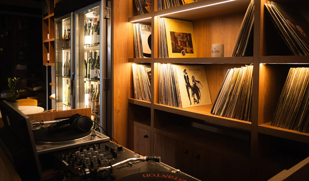 A turntable and shelves of vinyl records inside Strafilo wine bar.