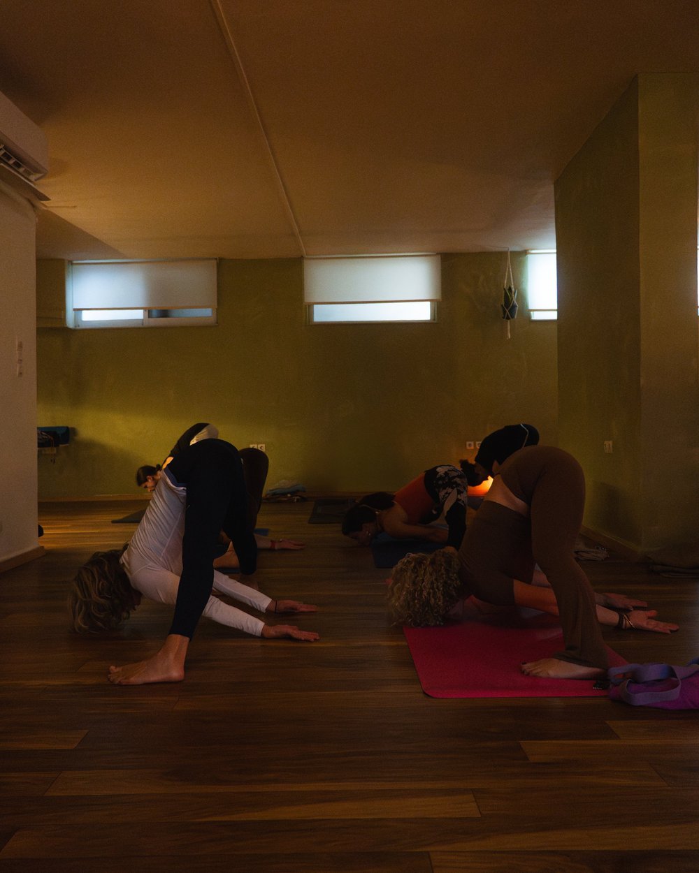Participants moving through a floor sequence in the yoga studio.
