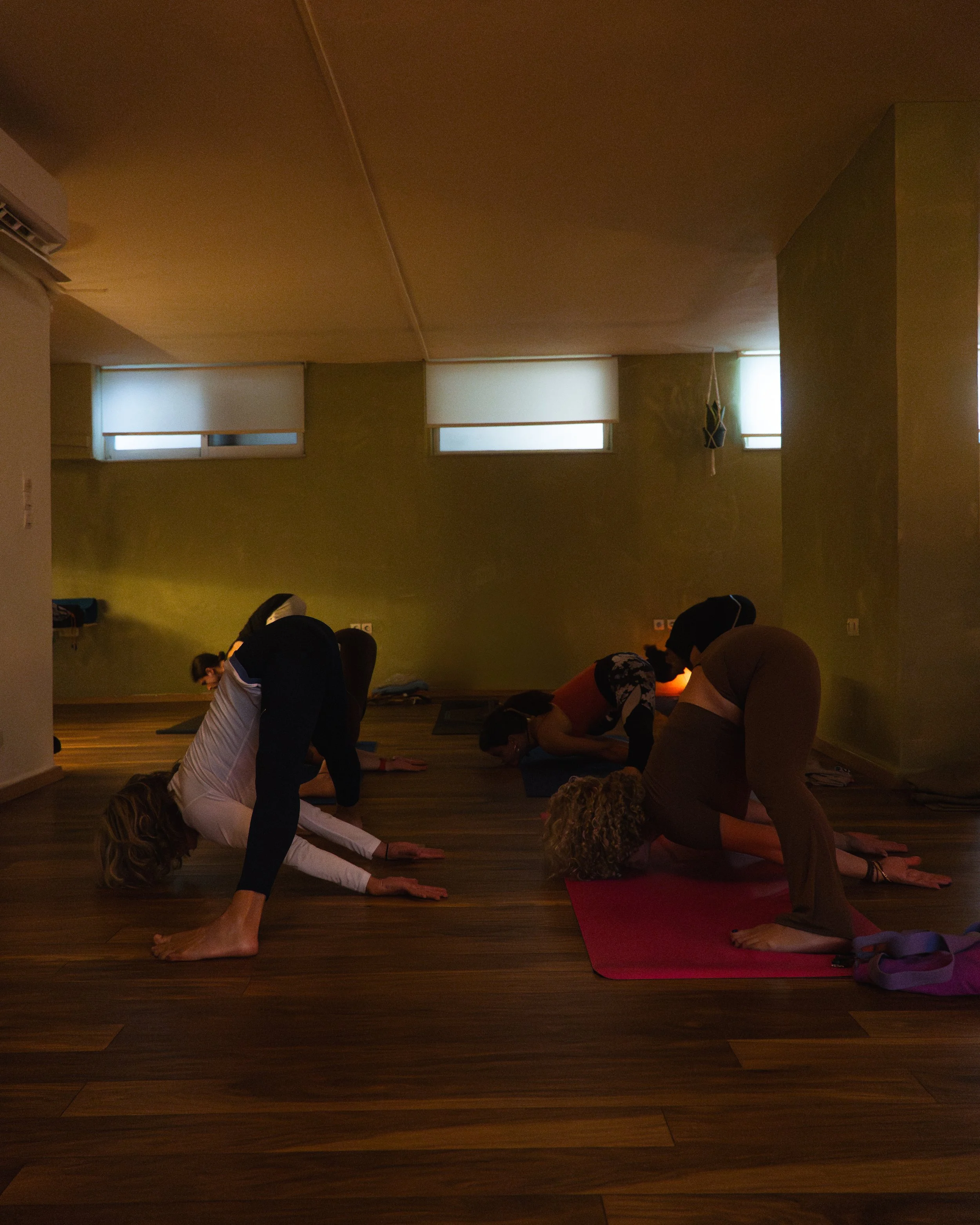 Participants moving through a floor sequence in the yoga studio.