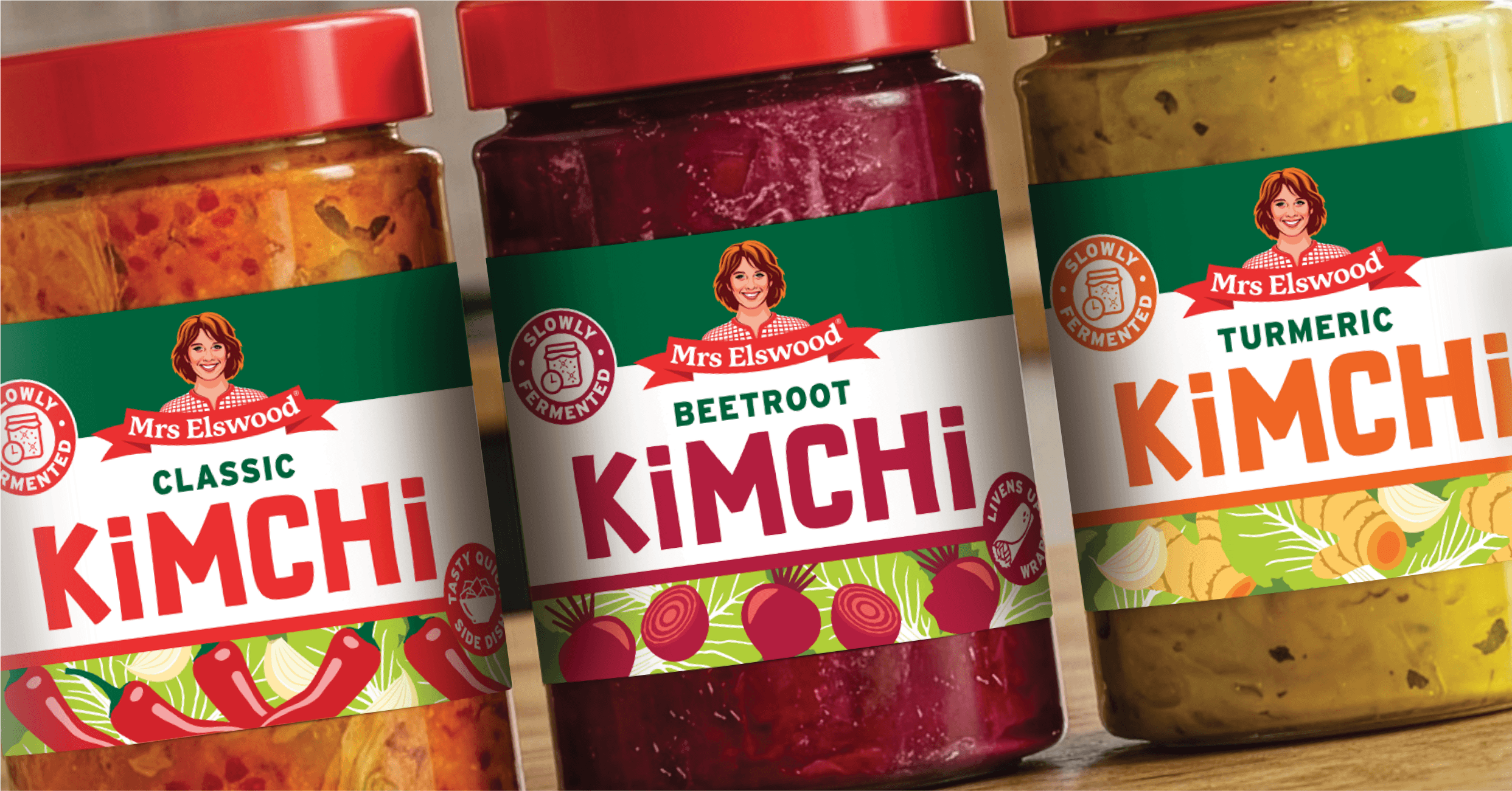 Close-up of Mrs. Elwood brand kimchi jars, featuring labels for classic, beetroot, and turmeric flavors, with colourful vegetable illustrations.