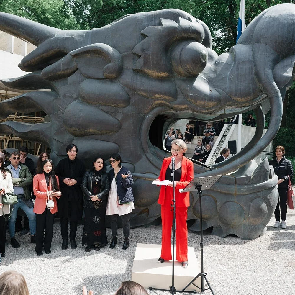 A woman in a red suit giving a speech