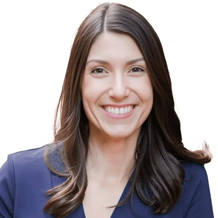 Tessa Balencic smiling with long brown hair in a navy blue top on a white background.