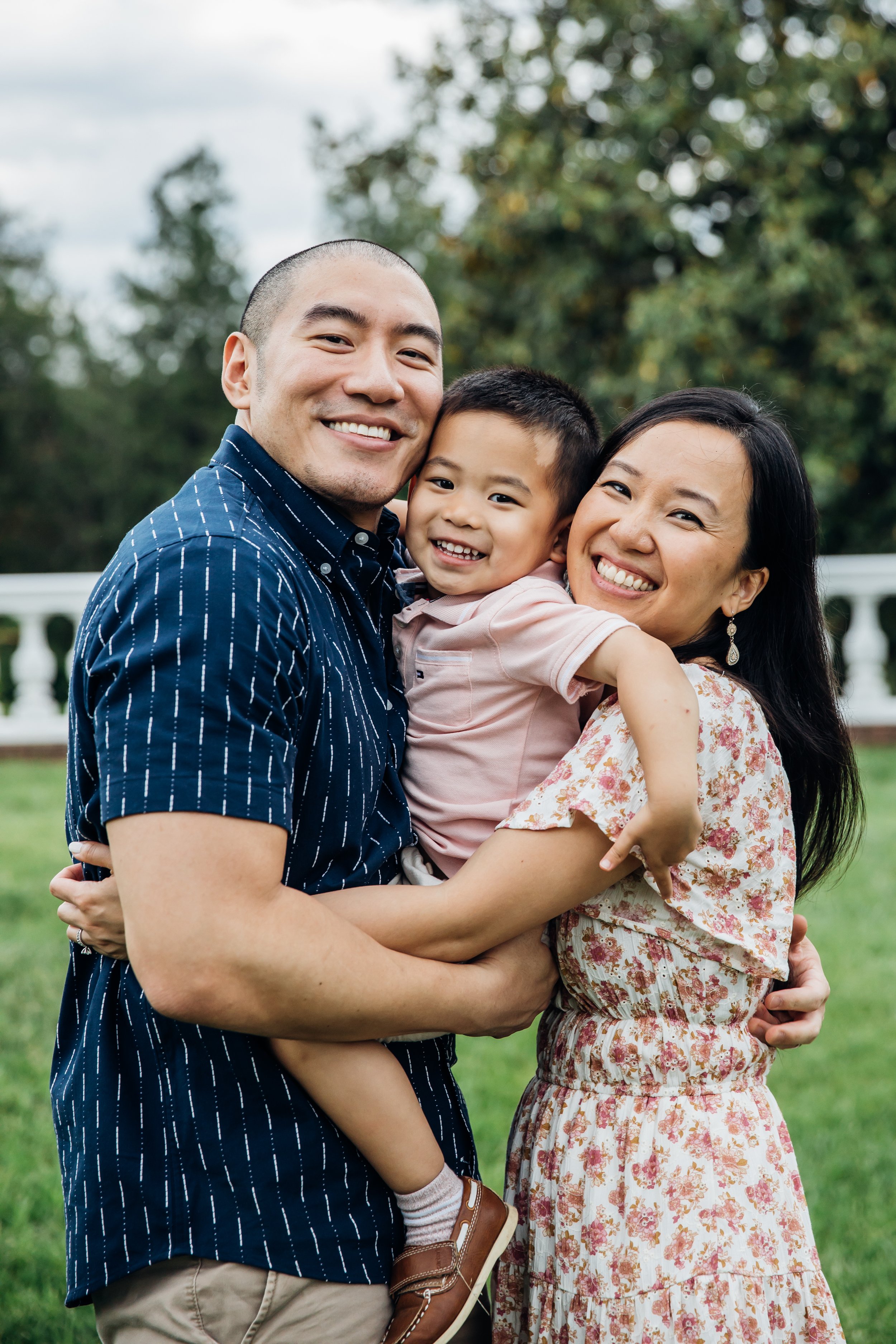 Family hugging and smiling for spring family portraits.