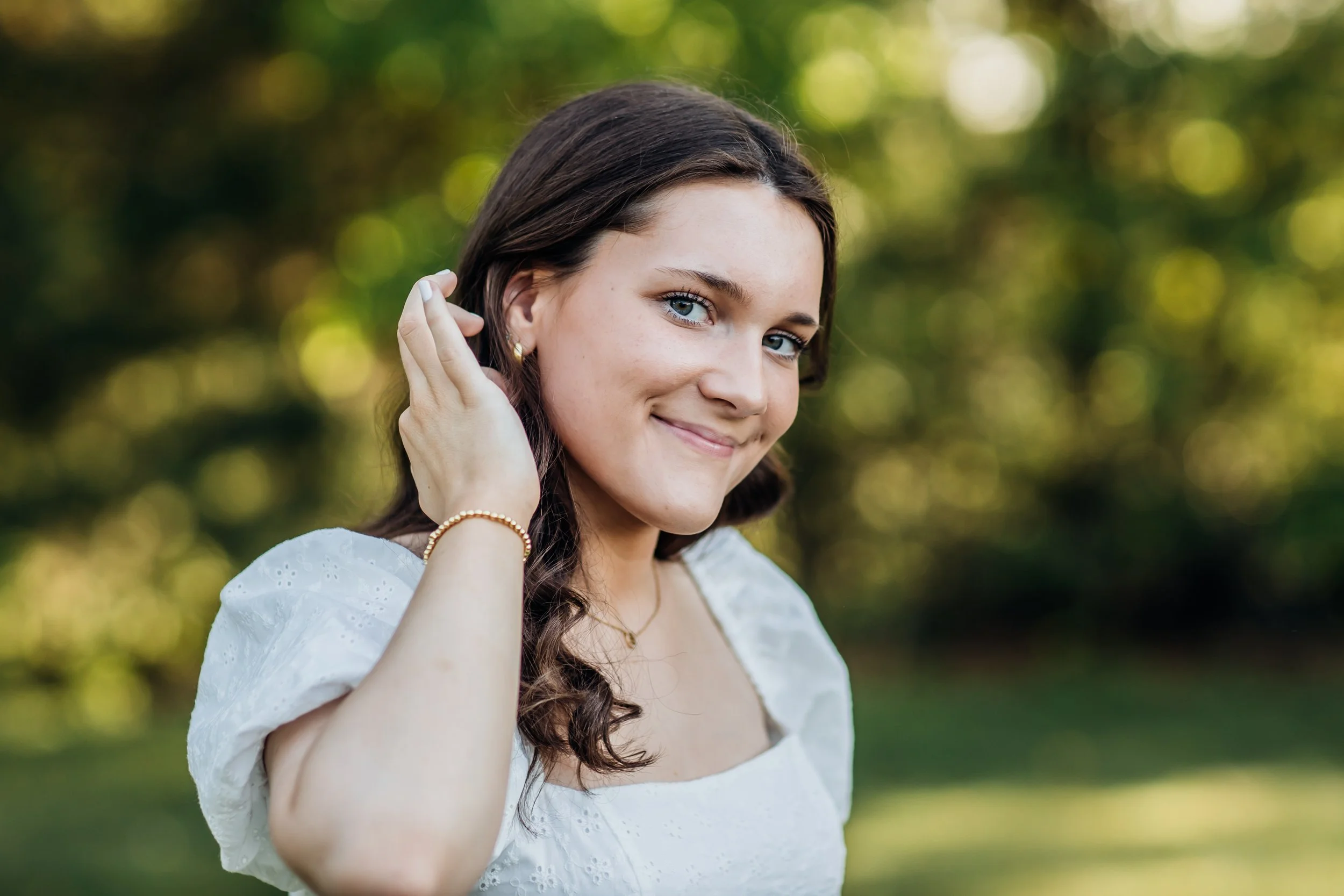 High School girl pulling hair back to look at camera.