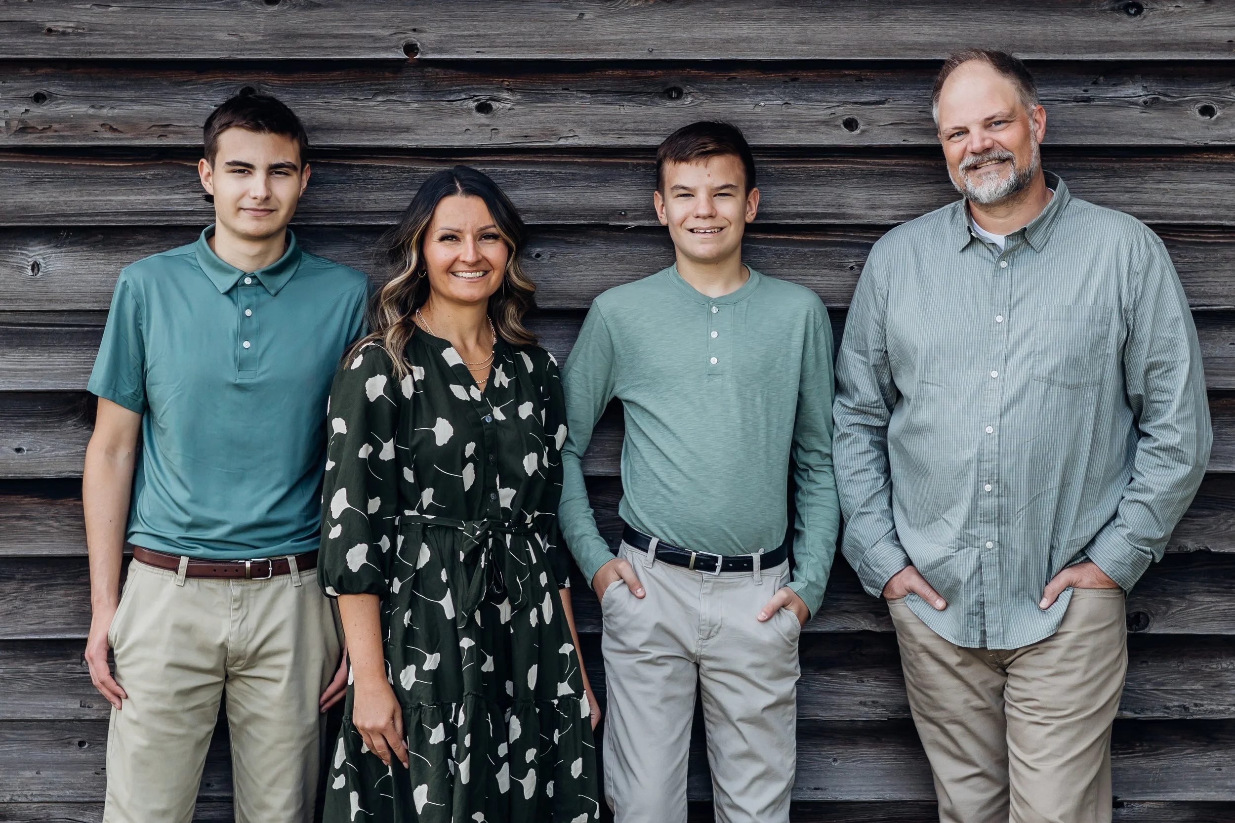 Family leaning against a barn in Bristow VA taken by local photographer.