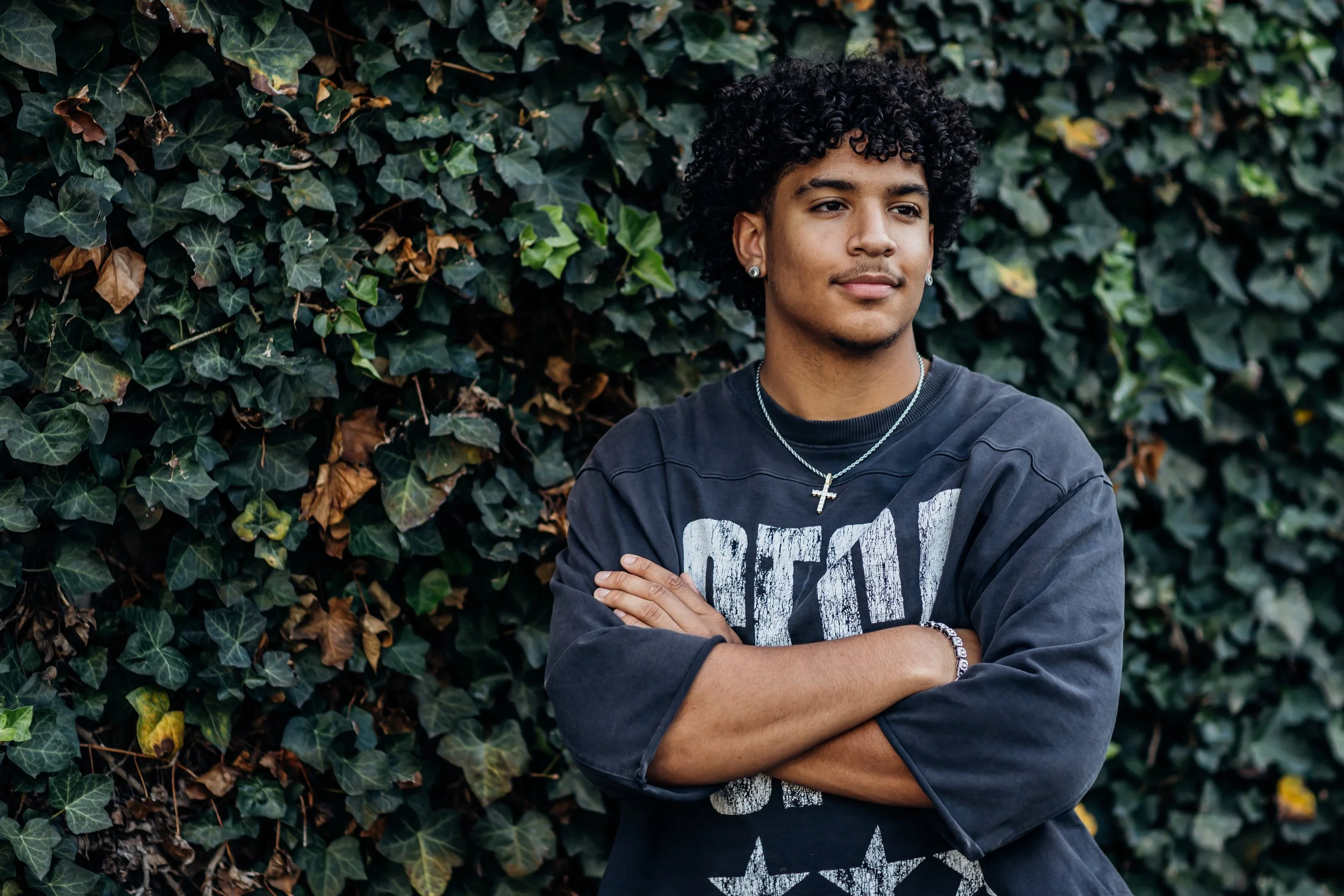 Senior standing near an ivy wall in Warrenton VA posing for Senior Photographer Gainesville VA