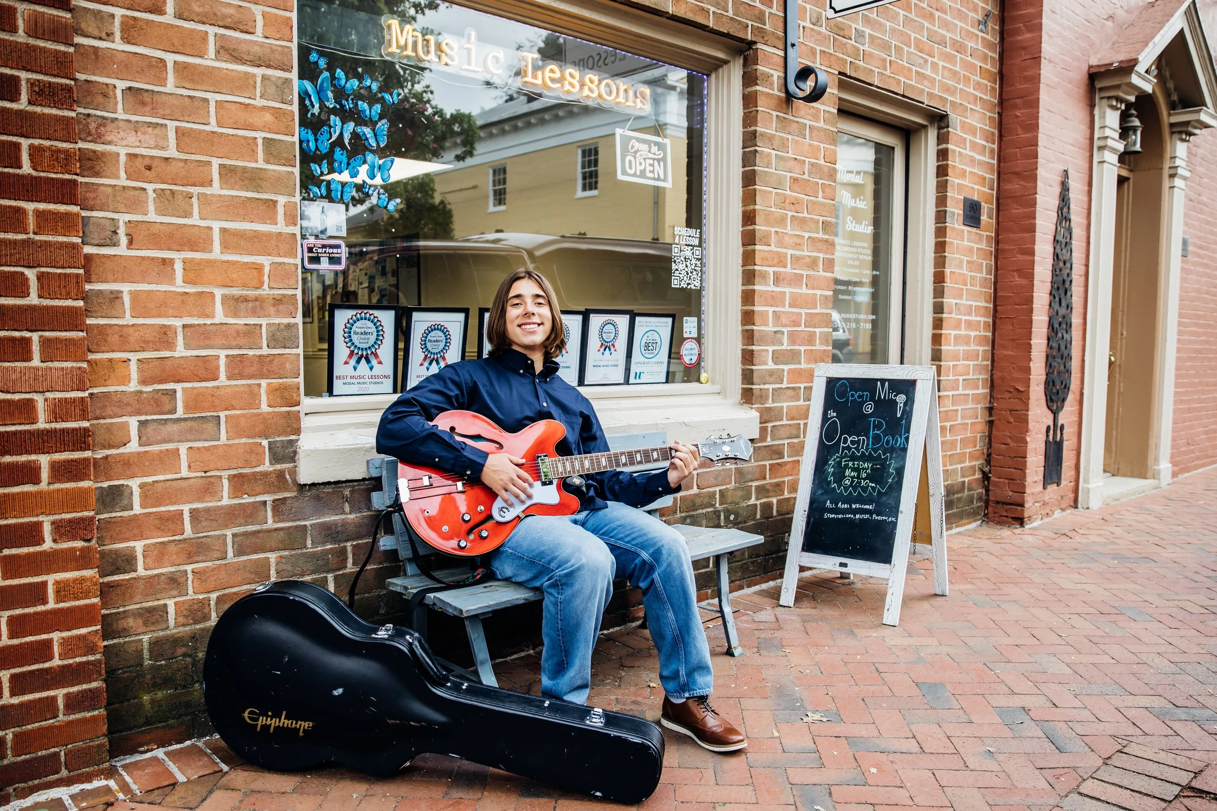 High School Senior playing guitar in front of Music Store in Warrenton VA