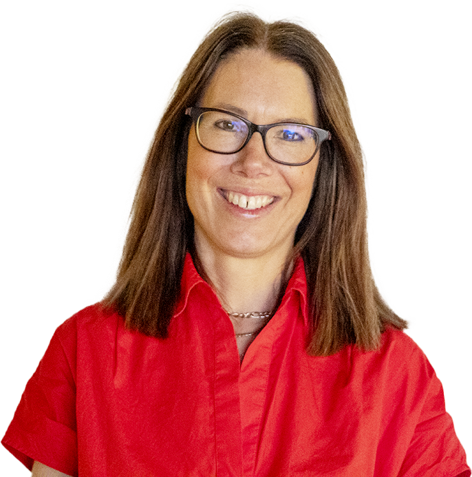 A woman with short brown hair wearing round glasses and a floral blouse.