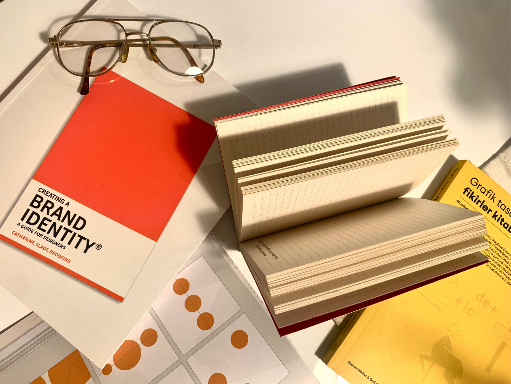 Branding materials with notebooks, color swatches, and design tools arranged on a desk