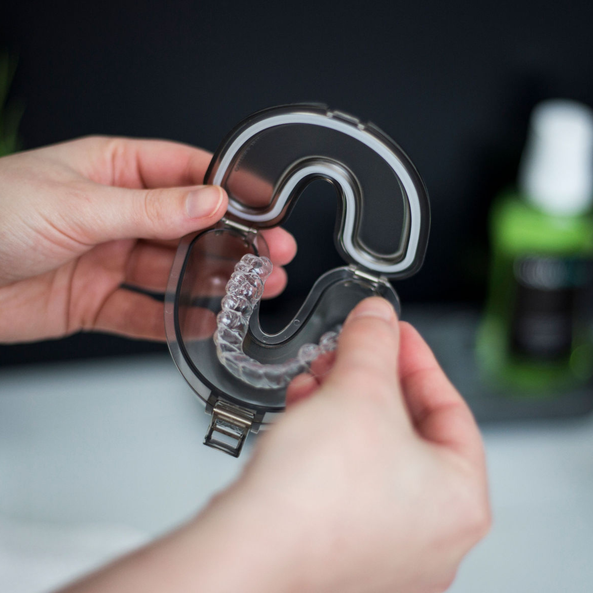 Close-up of a transparent dental night guard inside a leakproof retainer case