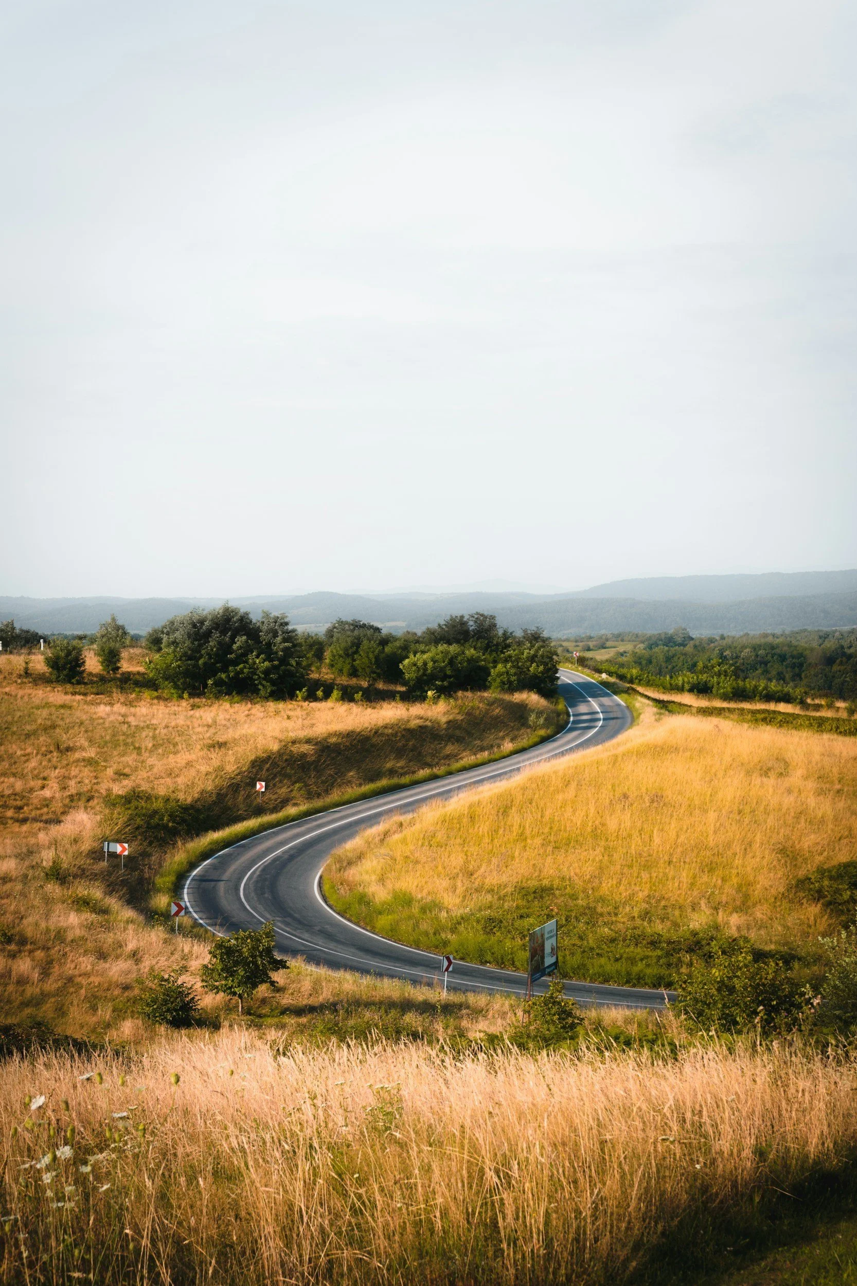 World's best road trips featuring scenic drives, boutique hotels, and gourmet restaurants. Convertible car on winding coastal road with ocean views