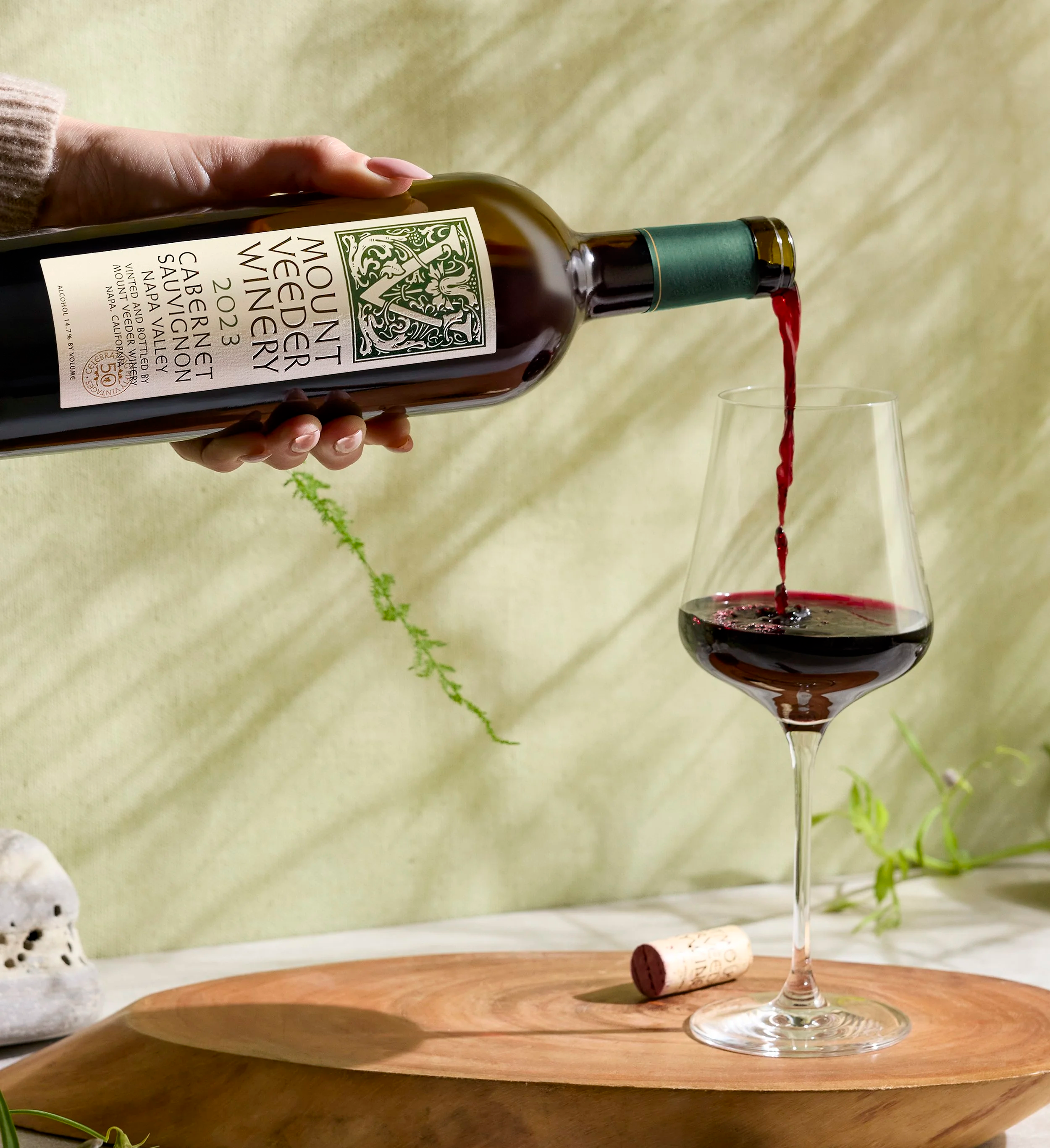 Mount Veeder Winery Napa Valley Cabernet Sauvignon being poured in front of green background
