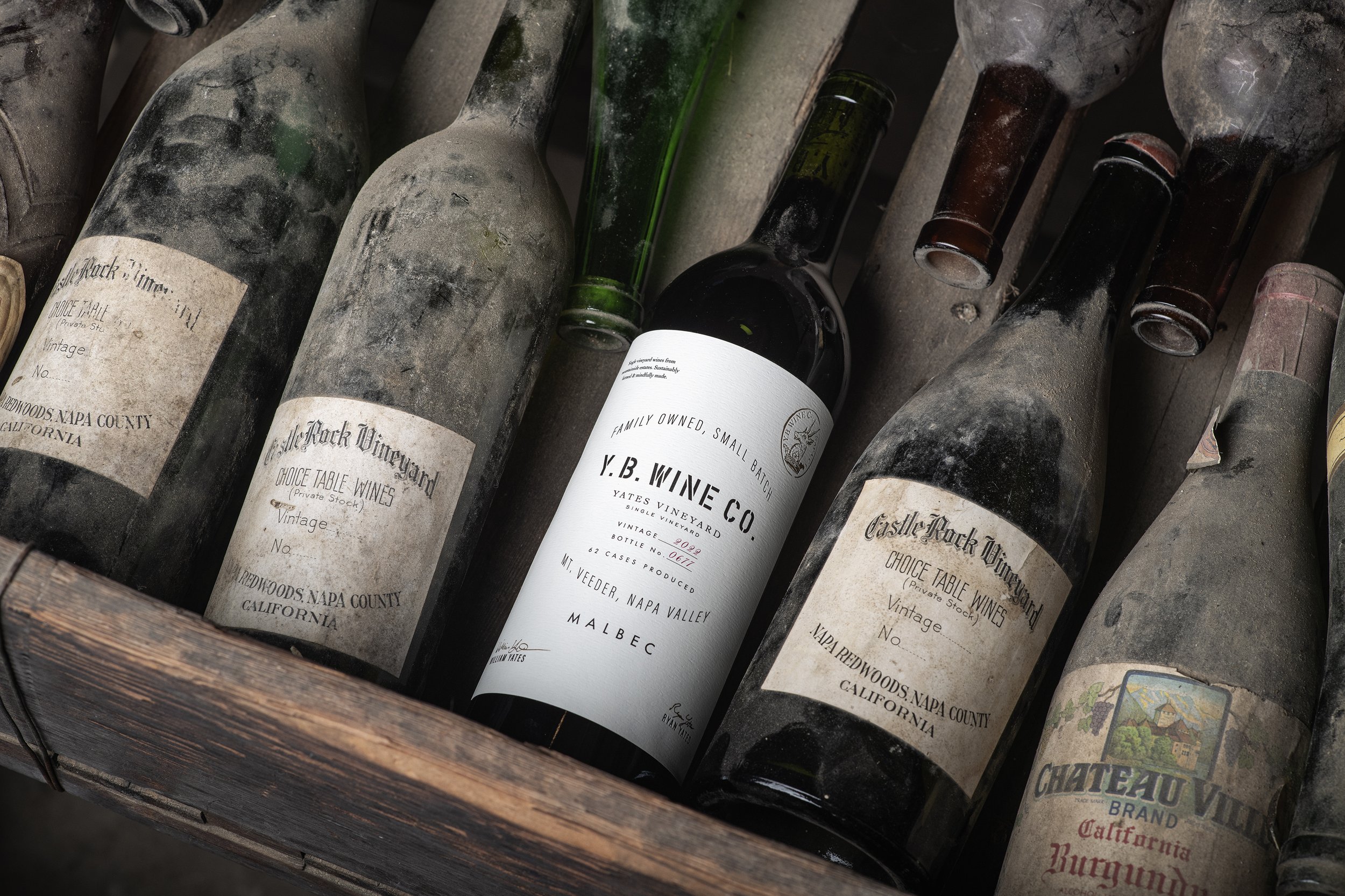 YB Wine Co Mount Veeder Napa Valley label displayed with vintage bottles