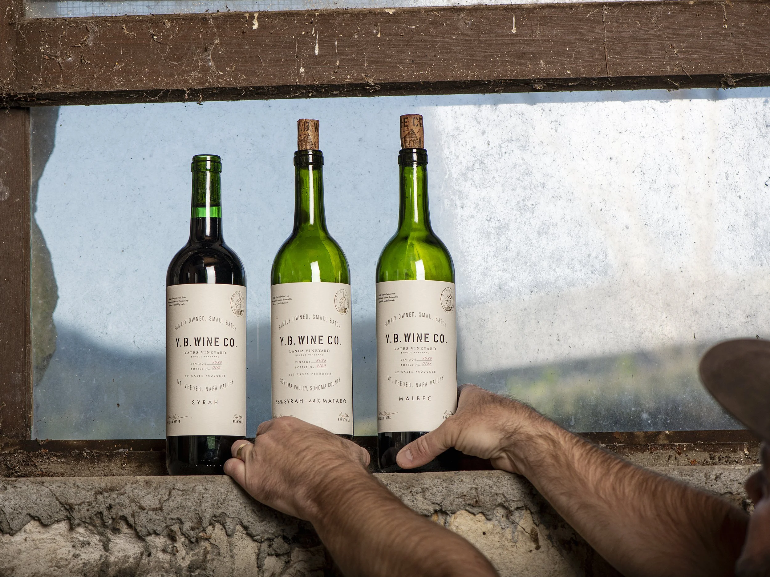 YB Wine Co Mount Veeder Napa Valley bottles sitting in window of barn