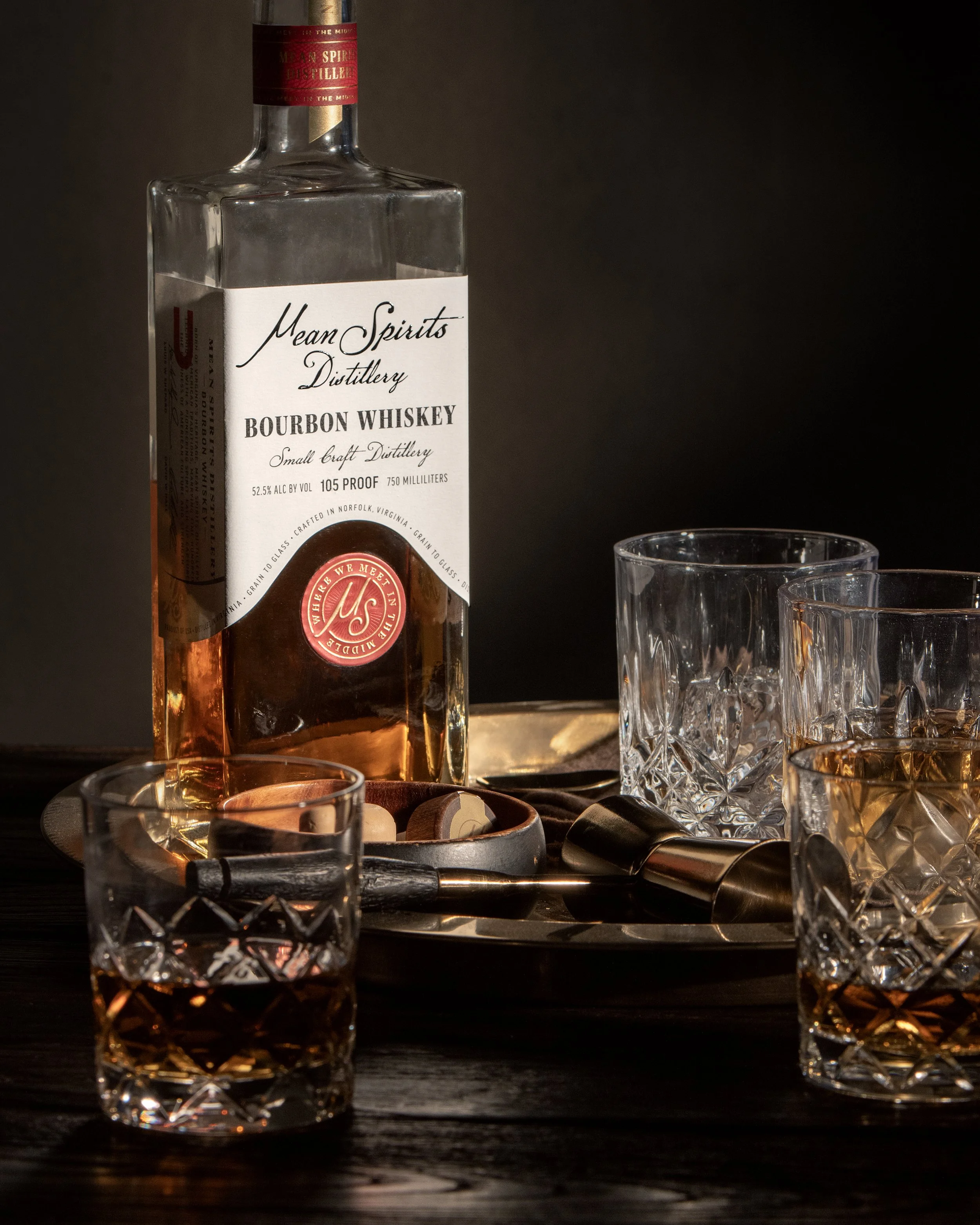 Mean Spirits Distillery Norfolk Virginia Bourbon Whiskey label sitting on table with glass of whiskey