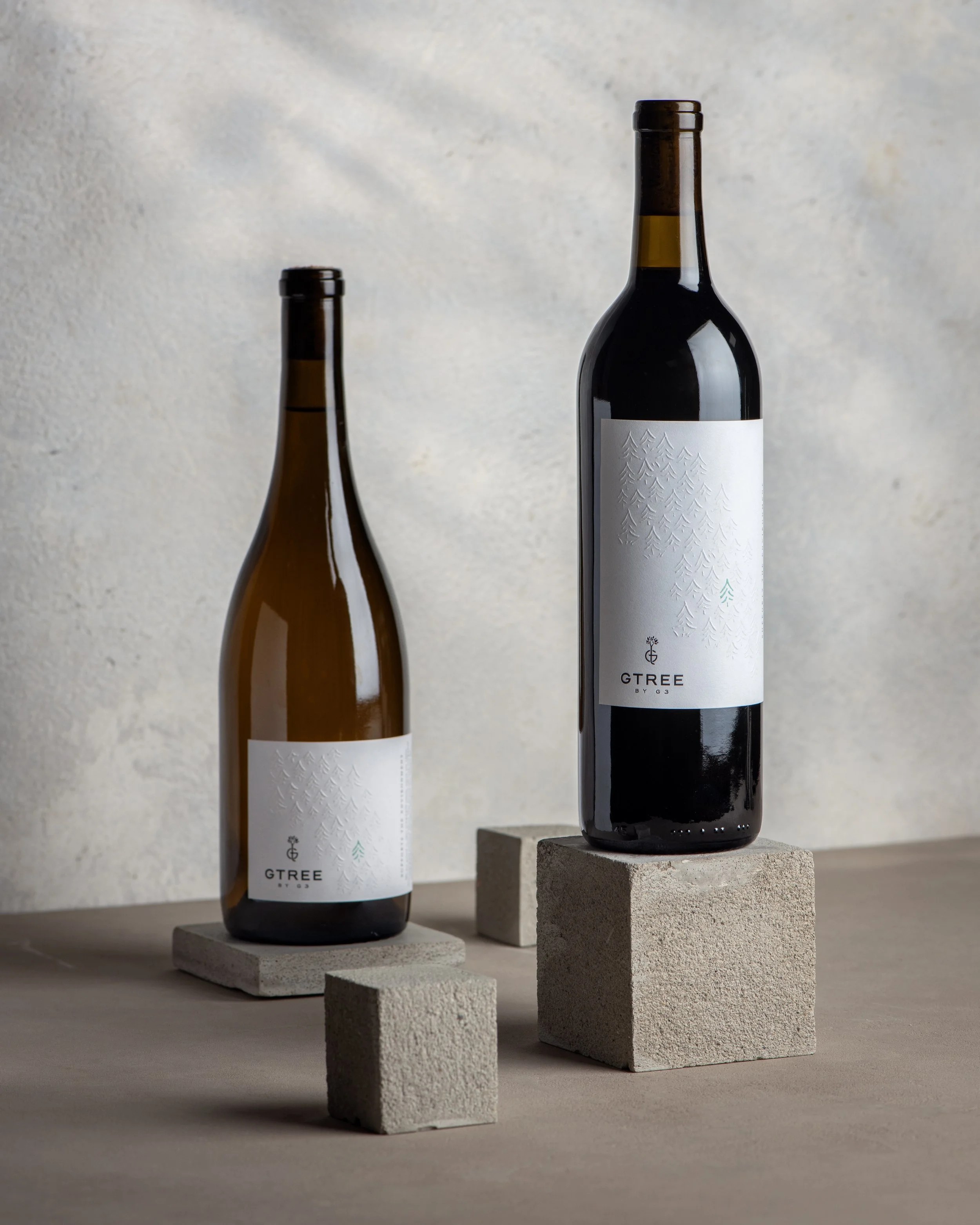 G3 GTREE Enterprises sustainability labels on wine bottles sitting on square stones
