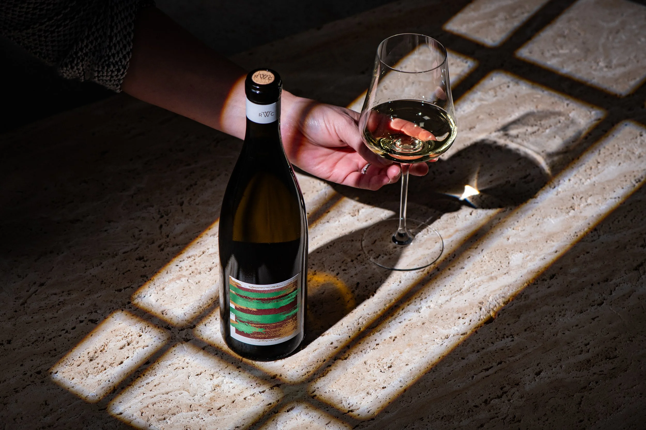 Rodney Strong Rowen Chardonnay with hand reaching for wine glass