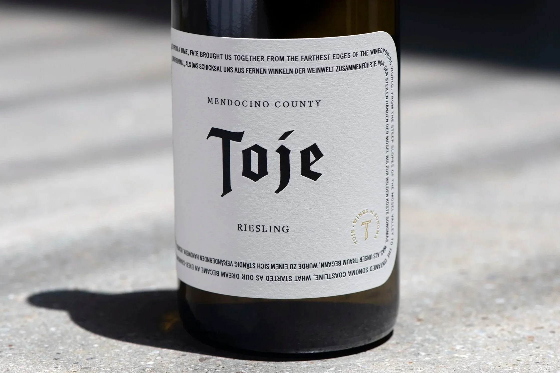 A close-up of a wine bottle with a white label, featuring black text that includes the words "Mendocino County" and "Riesling".
