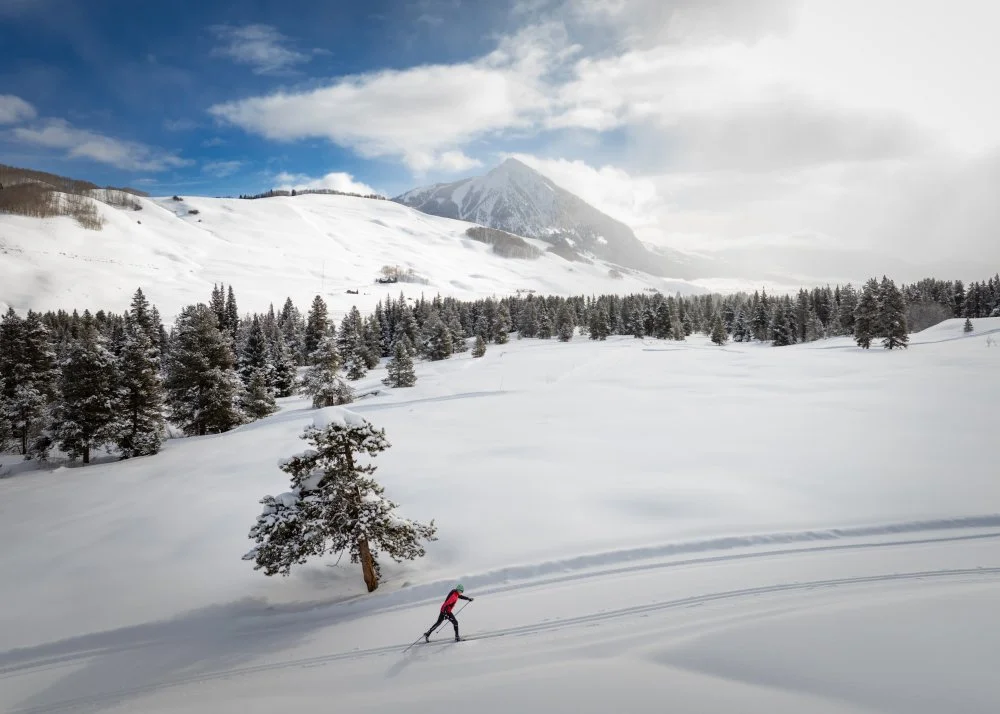 a lone skier skis with a beautiful background