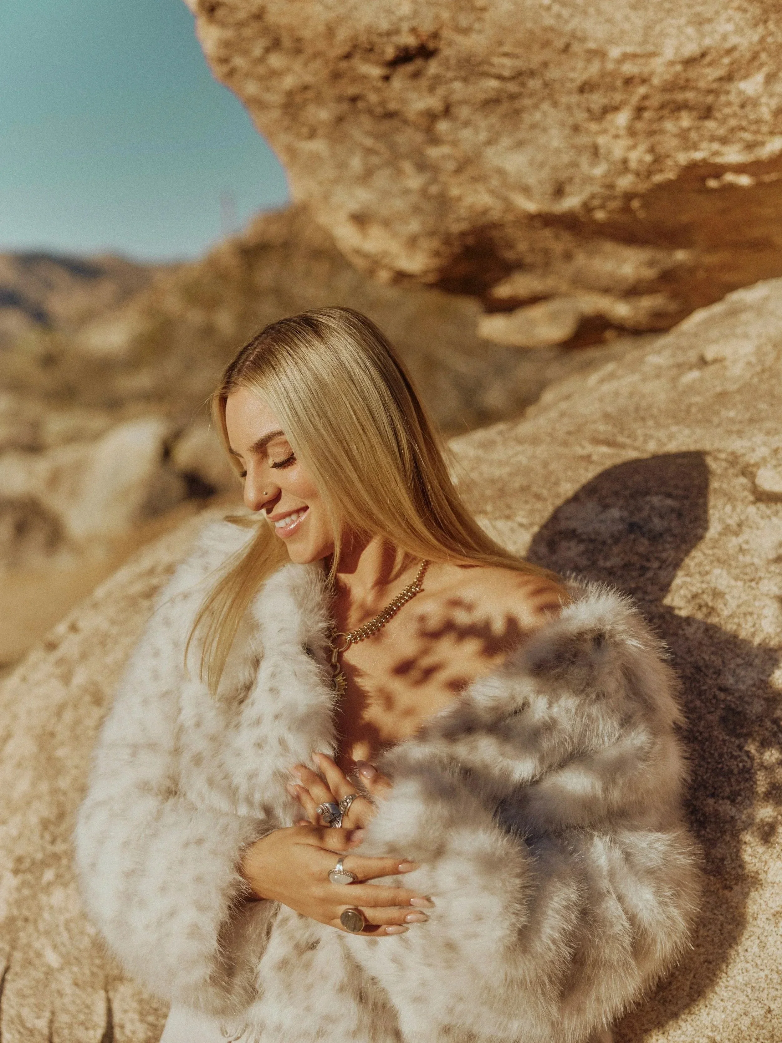Taj wearing a light fur coat