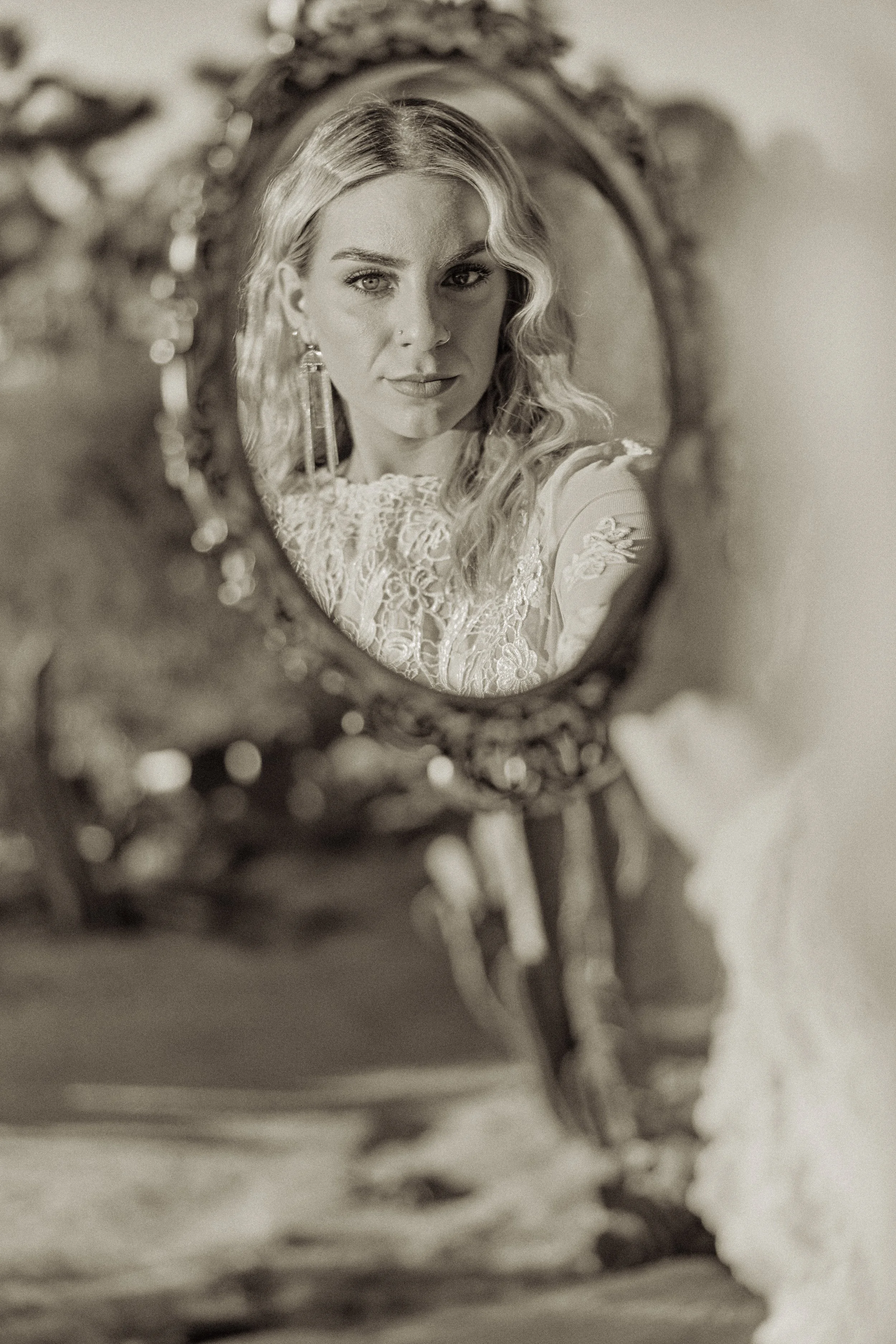 Close-up reflection of Taj face in an ornate mirror outdoors.