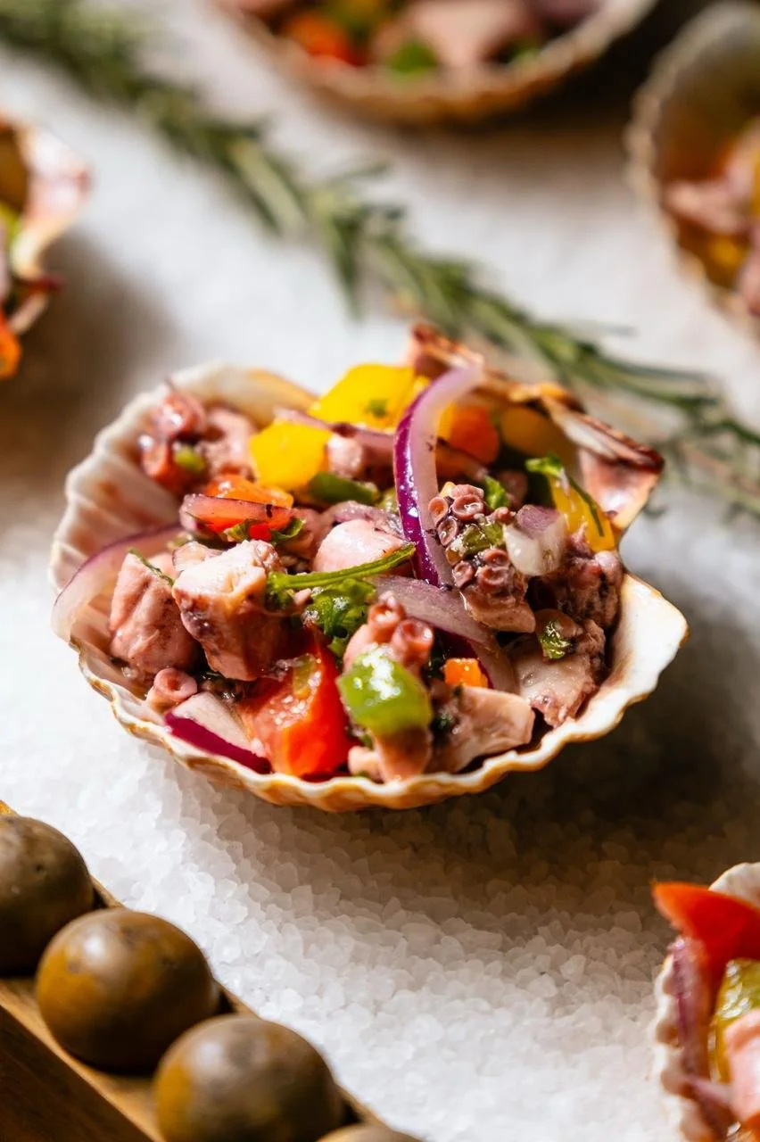 Salada de frutos do mar em concha decorada com ervas frescas.