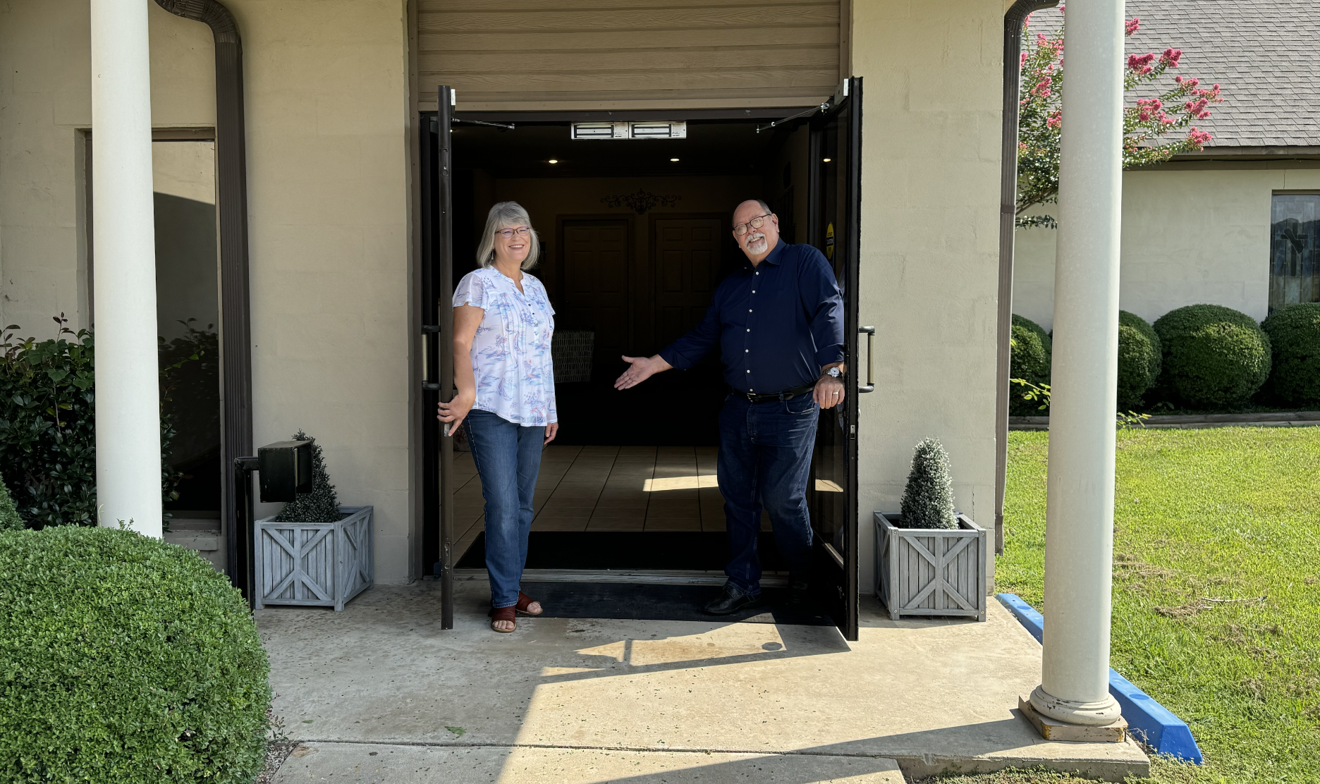 Visit our church front door picture - two folks welcoming people to church at front doors - expository Bible teaching at Foothills Bible Church