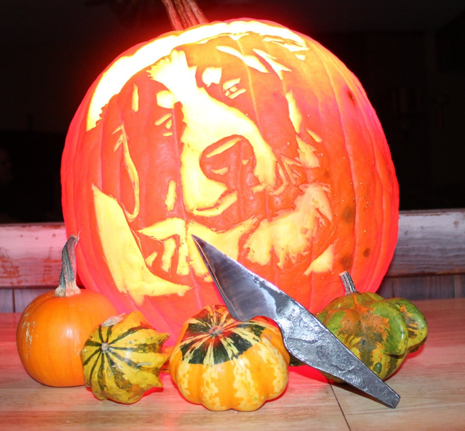 Hand forged kiridashi knife in front of carved pumpkin