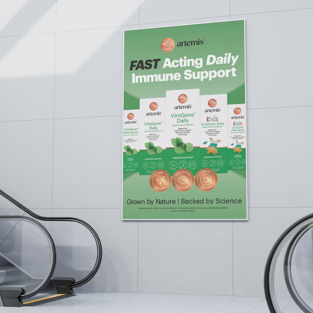 Green advertisement poster for Artemis ViroGone Daily and Kid's ViroGone Daily immune support products, featuring images of the products and text highlighting fast acting, natural, and tasty features, located on a wall near escalators.