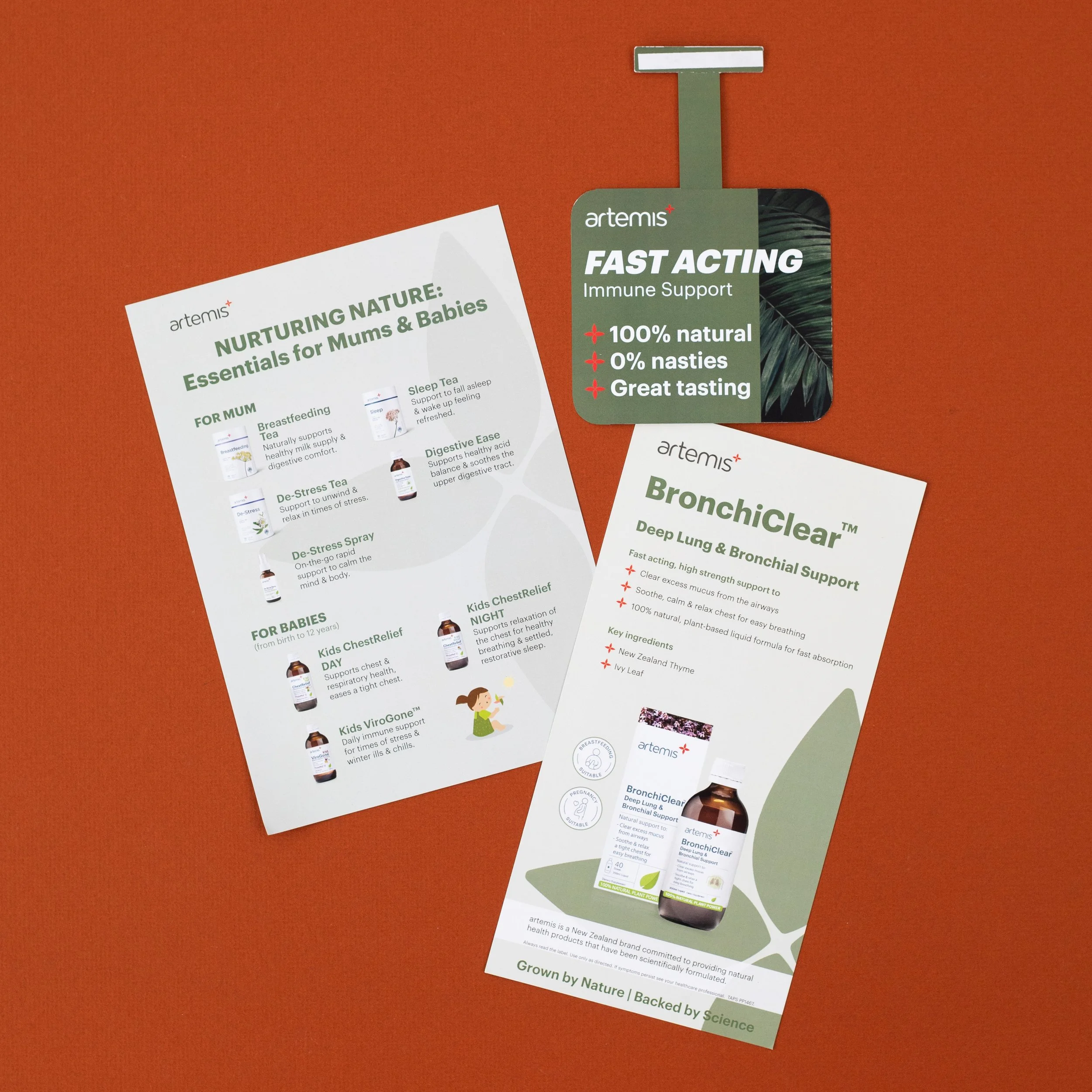 Two informational flyers from Artemis brand on a red background. One flyer promotes natural health products for moms and babies, with sections on breastfeeding tea, sleep tea, digestive ease, de-stress spray, and products for babies like Kids Chest R