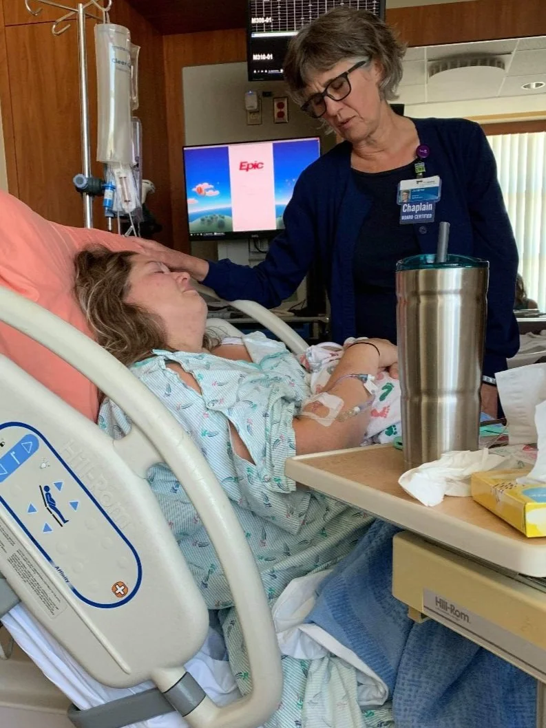 Vallen and Evelyns Hospital scene with a chaplain visiting to pray over Vallen in a hospital bed, holding Evelyn James.