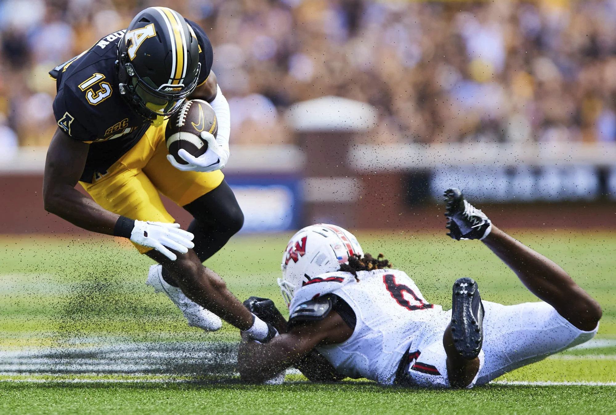 Raequan Ousley (6) of Gardner-Webb Bulldogs tackles Christian Horn (13)  of Appalachian State Mountaineers. Mountaineers go on to win 45-25 at Kidd Brewer Stadium in Boone, NC on Sep 2, 2023.