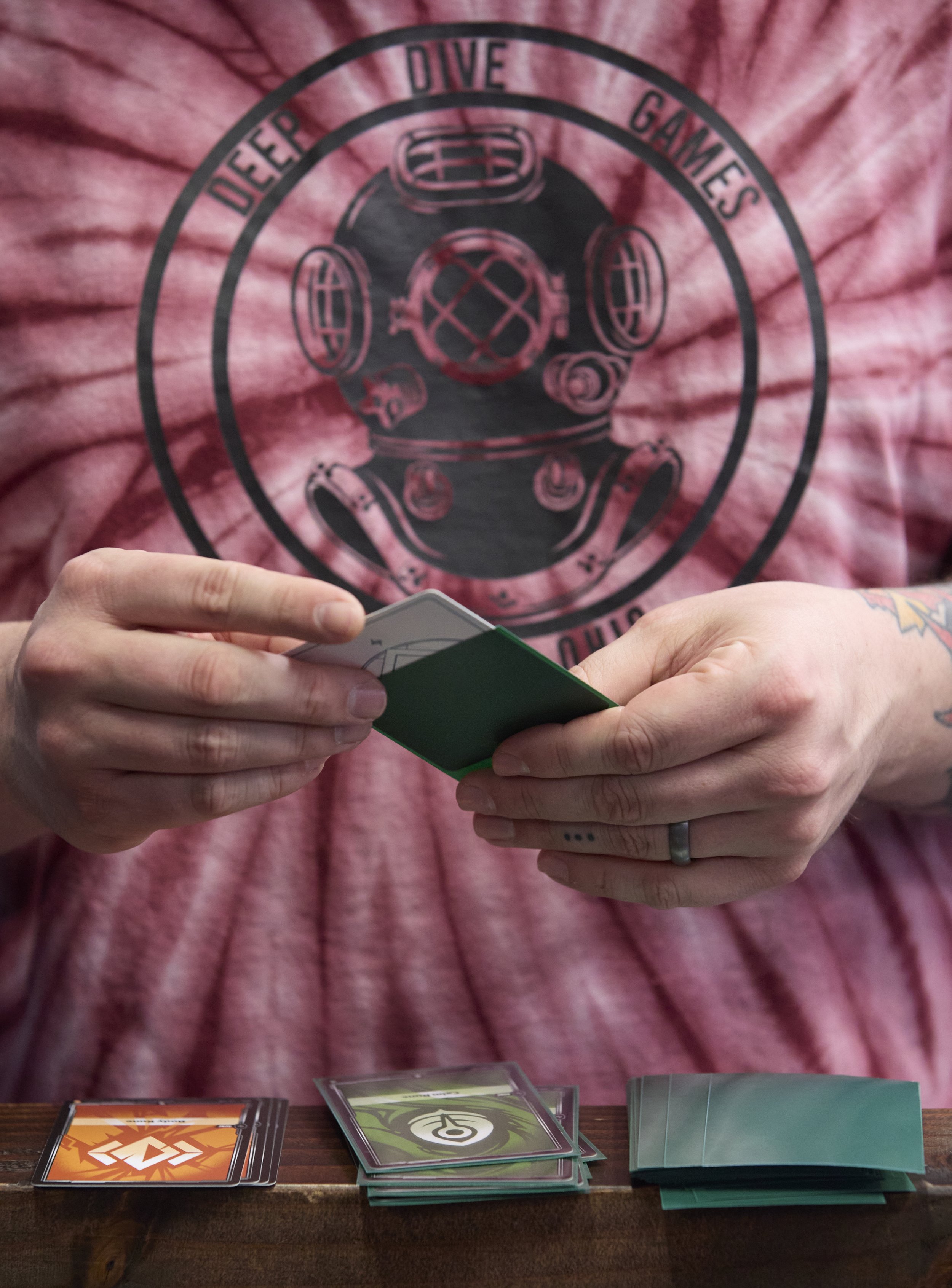 Store owner Eric Smith puts his Riftbound cards into sleeves for protection before he plays in the release day event on Nov 1, 2025, at Deep Dive Games in Athens, Ohio. Riftbound was released on Oct 31, 2025. 