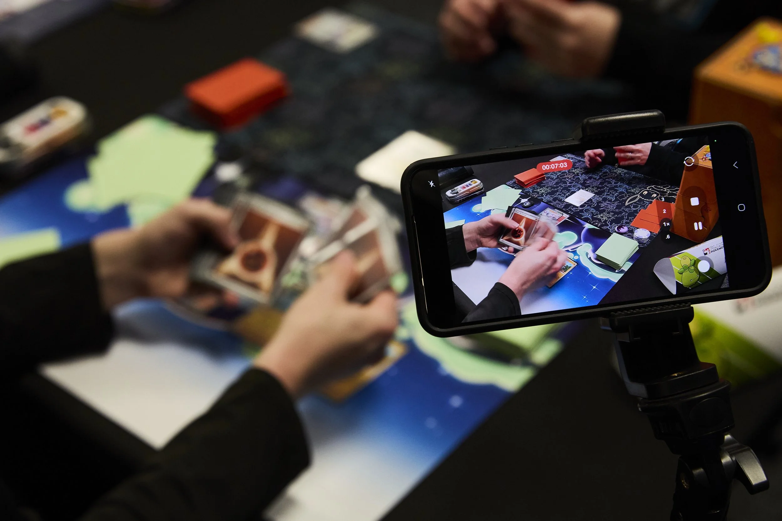 Andrew Krebs films his Pokémon card game to keep track of his moves and his opponents at Deep Dive Games in Athens, Ohio, on Oct 27, 2025. Krebs, a regular at Deep Dive Games, has been playing Pokémon since he was a kid and continues to play and comp
