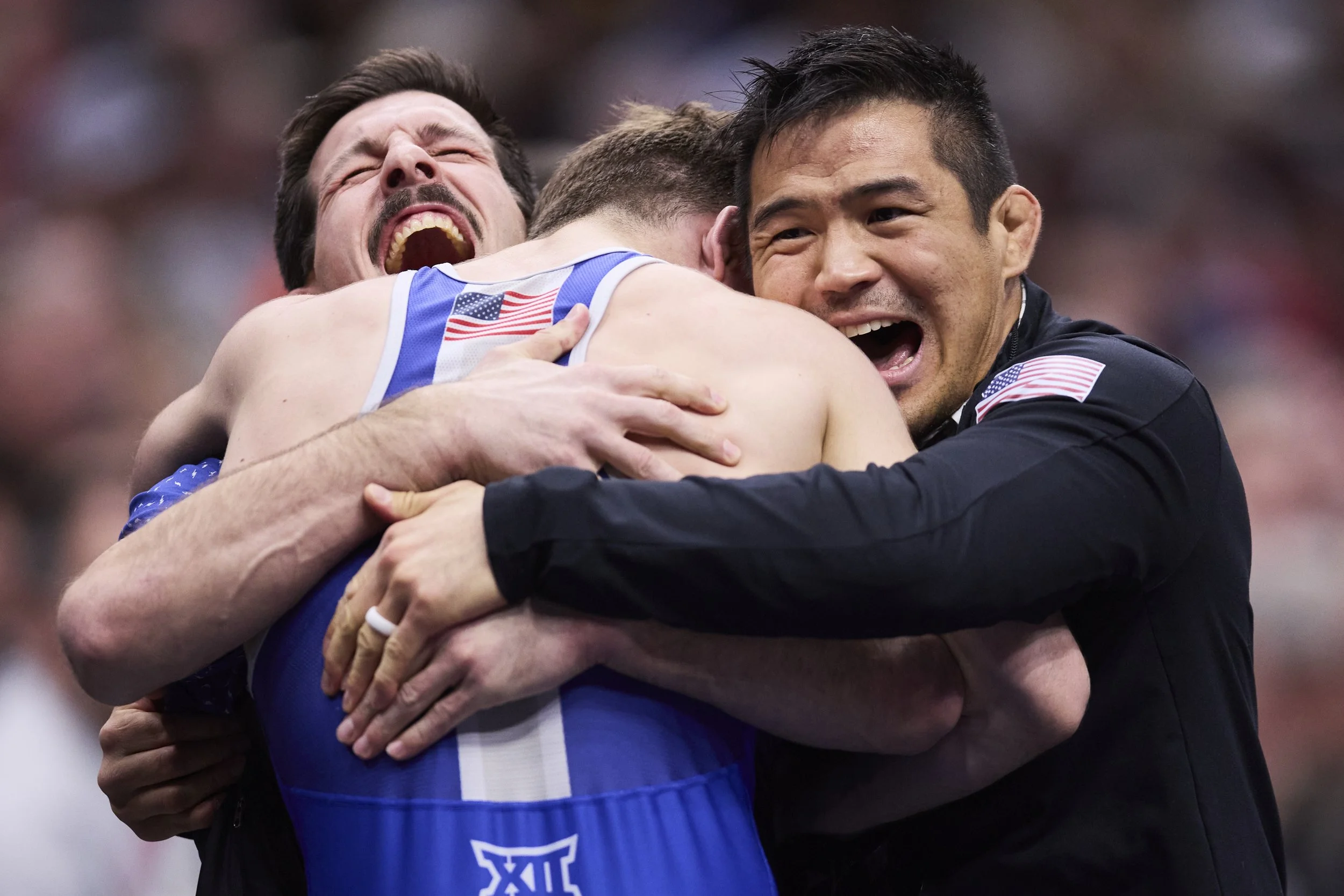Carter Nogle celebrates in his coaches arms, Joe Johnston and Chris Heilma, after become an All-American at NCAA Wrestling Nationals in Cleveland, Ohio on March 20, 2026. 

