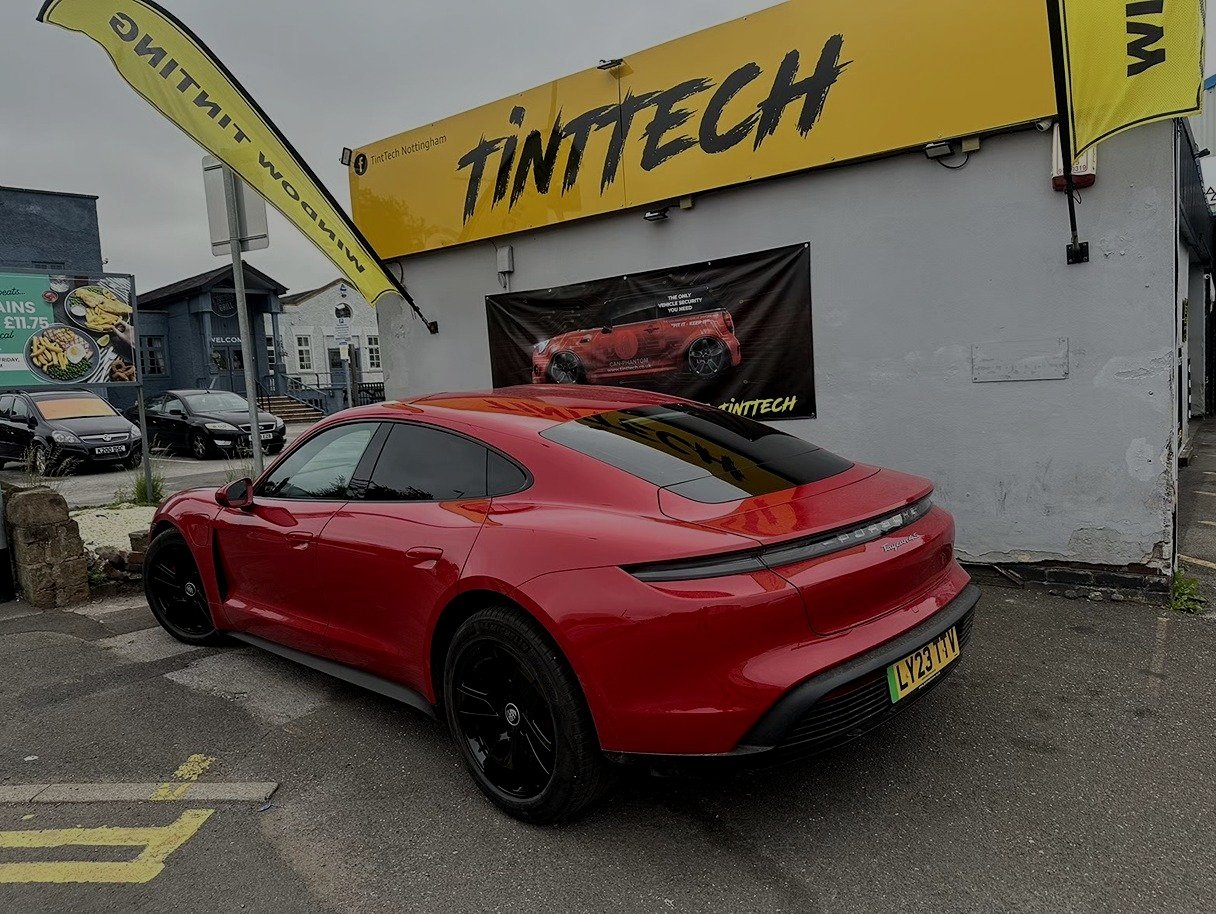 Red Porsche Taycan with tinted rear windows outside the TintTech Nottingham studio