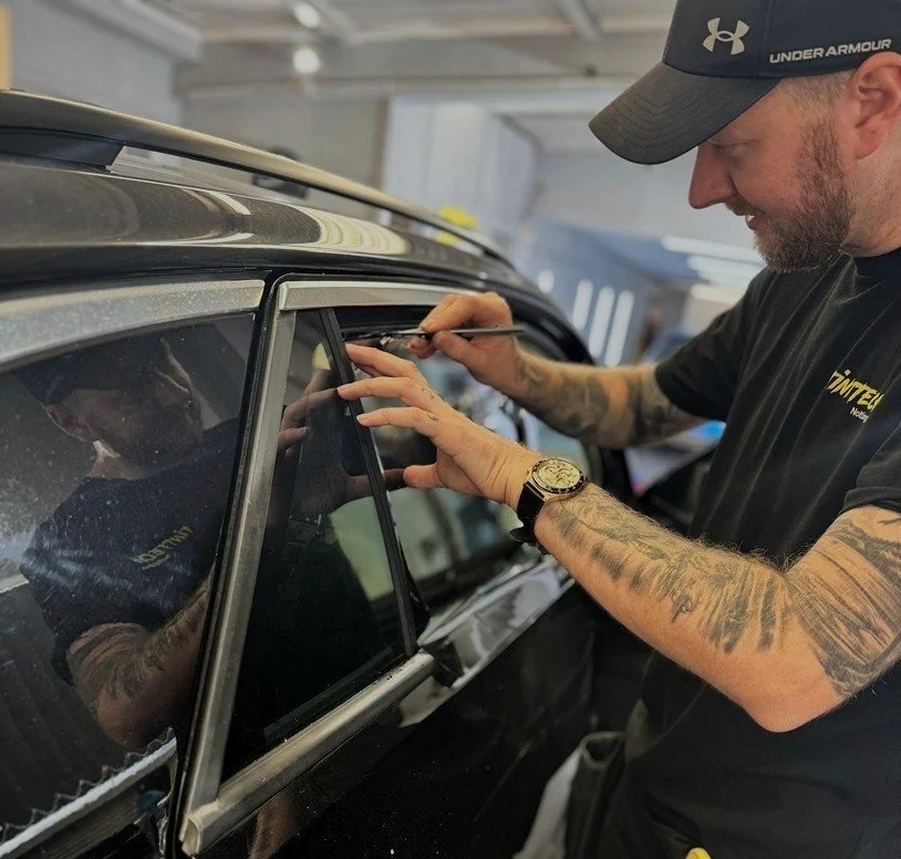 Window film being fitted by hand to a car door at TintTech Nottingham