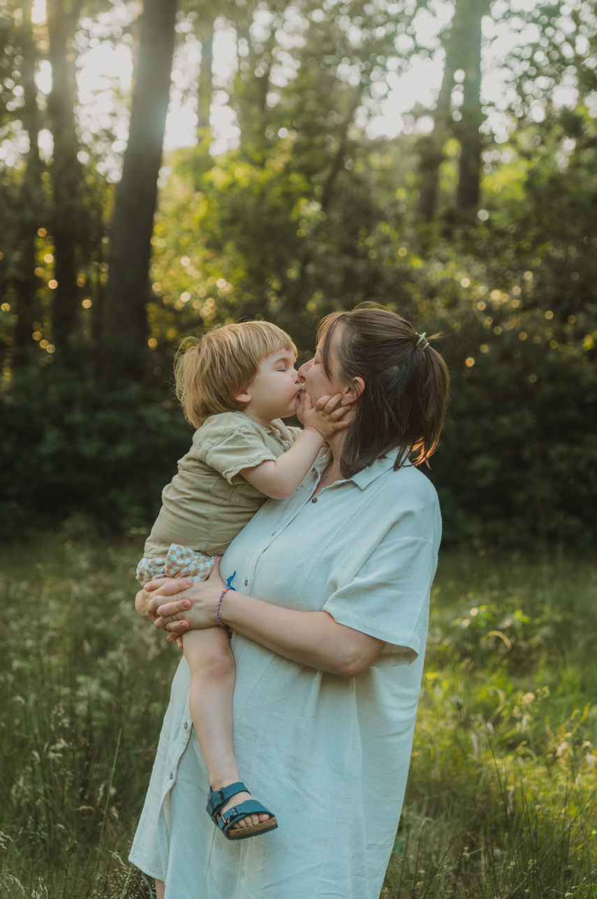 mama en kind geven een kus in de natuur