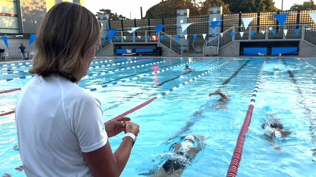 Coach Lorna times her swimming students.