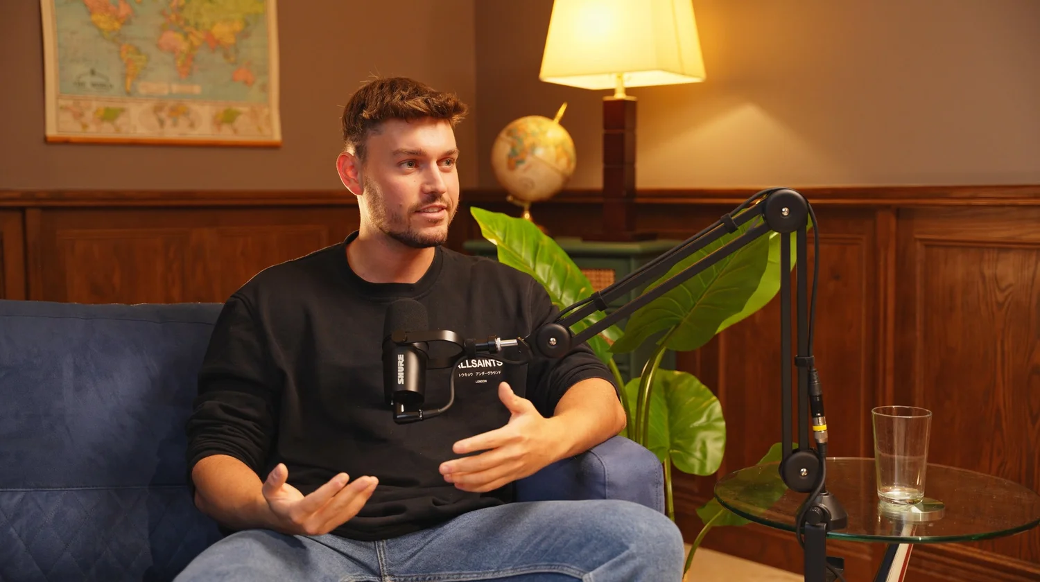 Studio One at Cheshire Podcast Studio, a warm wood-panelled podcast set with velvet seating