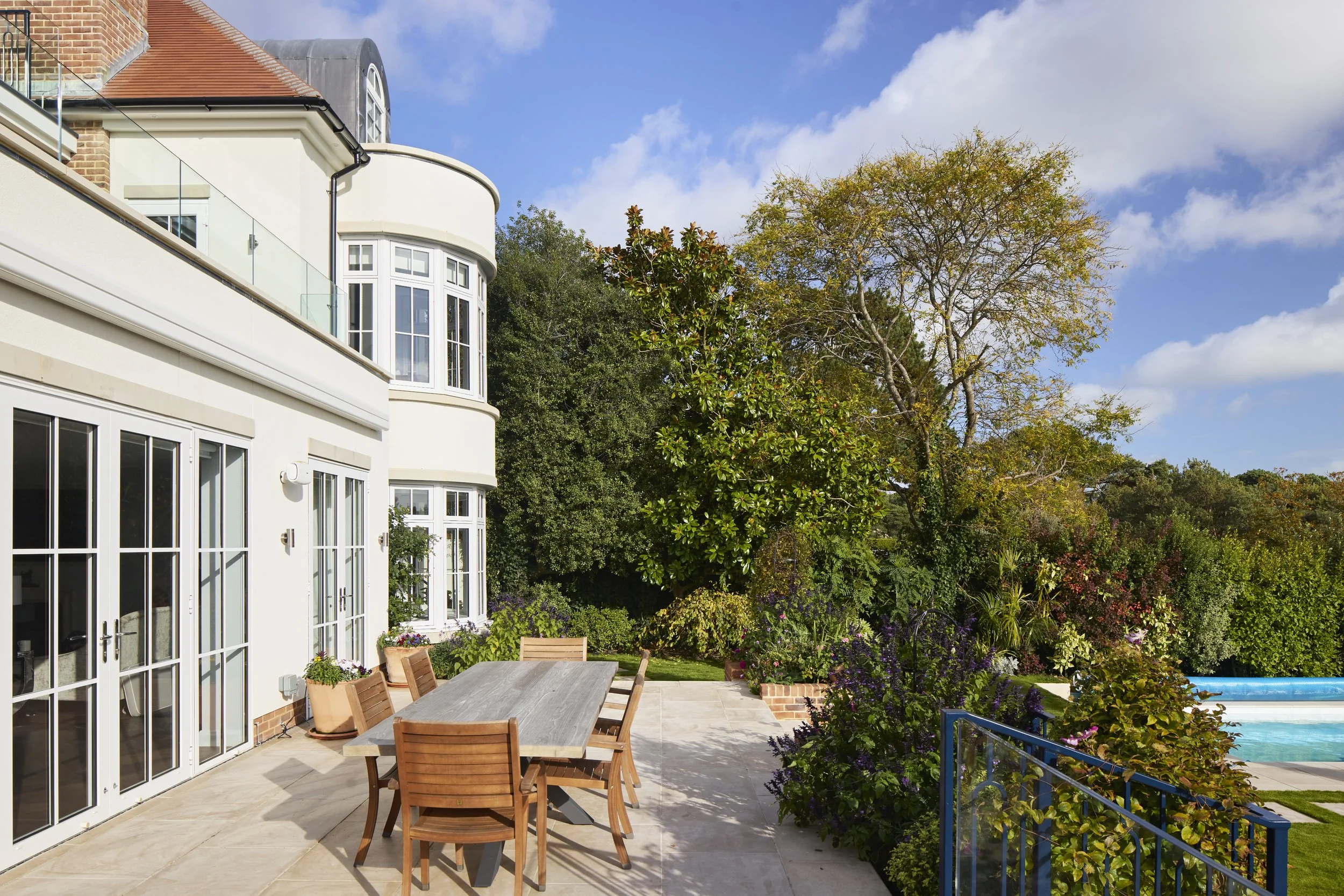 Rear garden at Over Links with swimming pool, terraces and glazed balconies