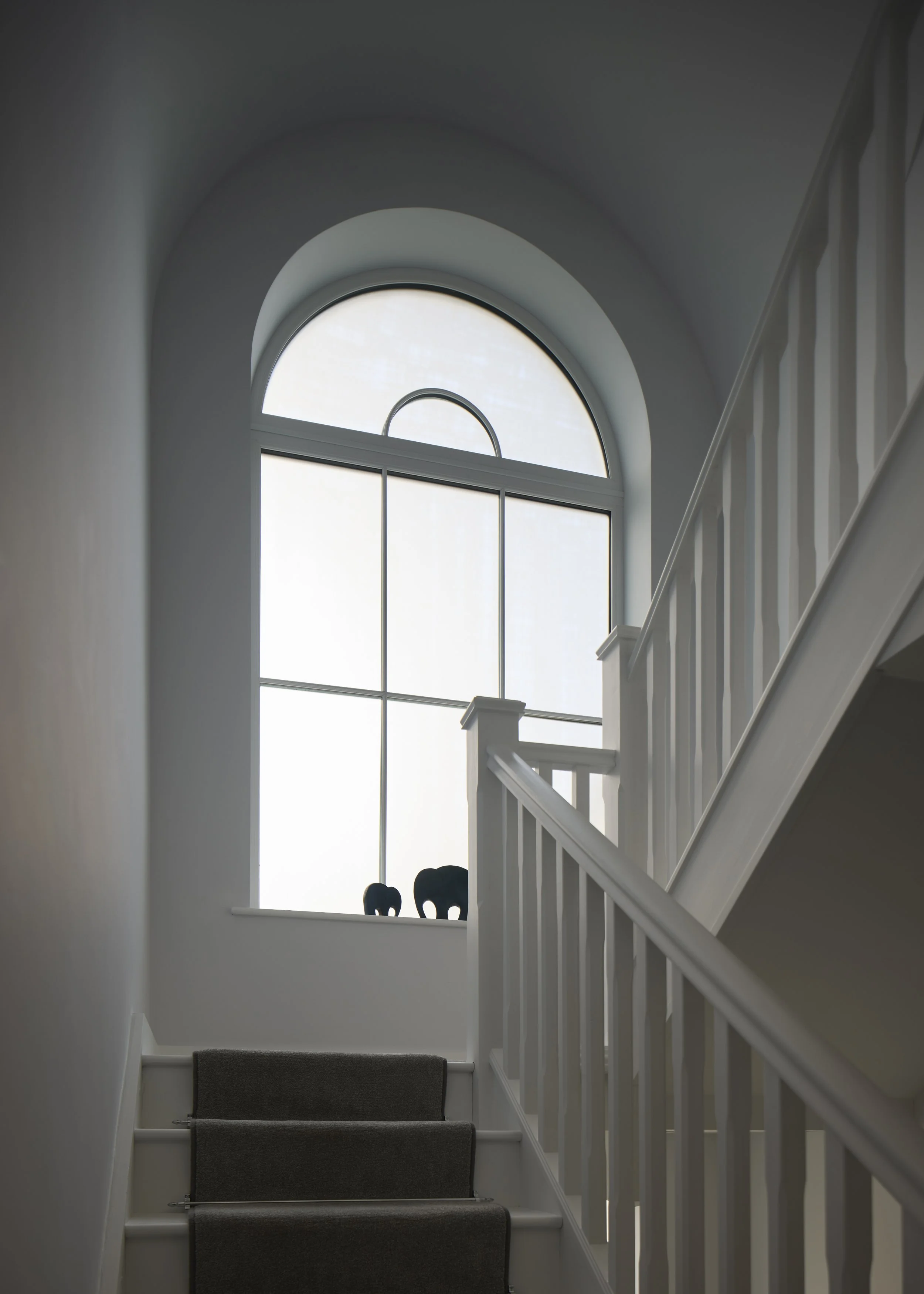 Staircase at Over Links with an arched window bringing natural light into the stairwell