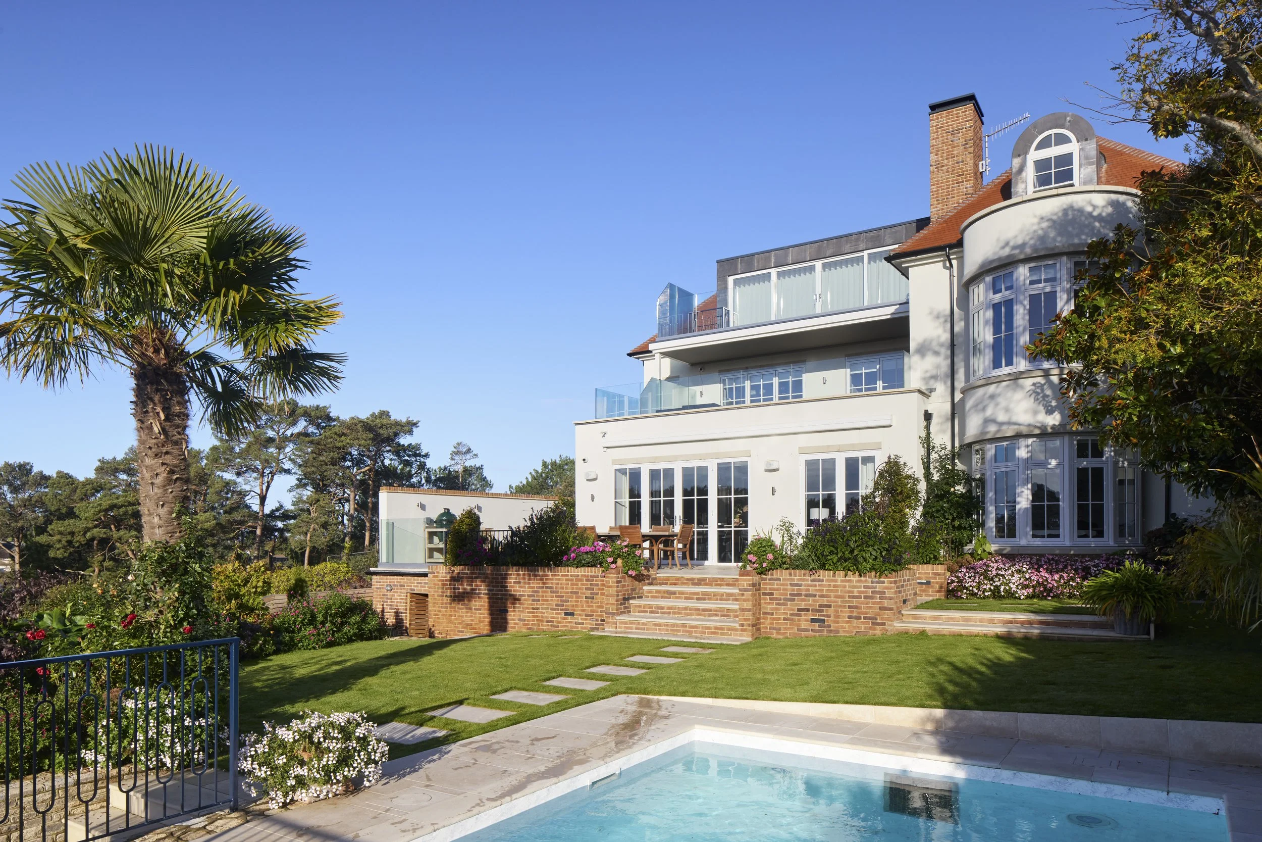 Rear garden at Over Links with swimming pool, terraces and glazed balconies
