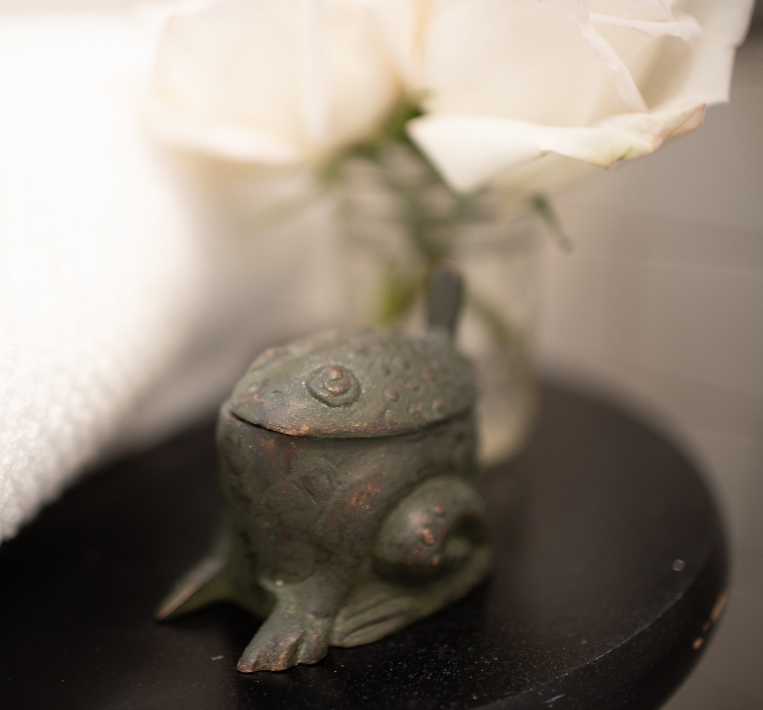 This cherished frog sits on an antique black stool adding unexpected charm to this vintaged tiled bath.