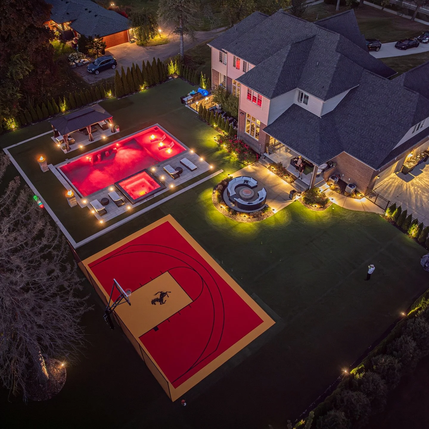 this project turned out incredible! ✨ the lighting at night really makes it pop 🌟 let&rsquo;s turn your dream backyard into reality too 💭 DM us today to get started 📲 #landscapedesign #basketballcourt #landscapelighting