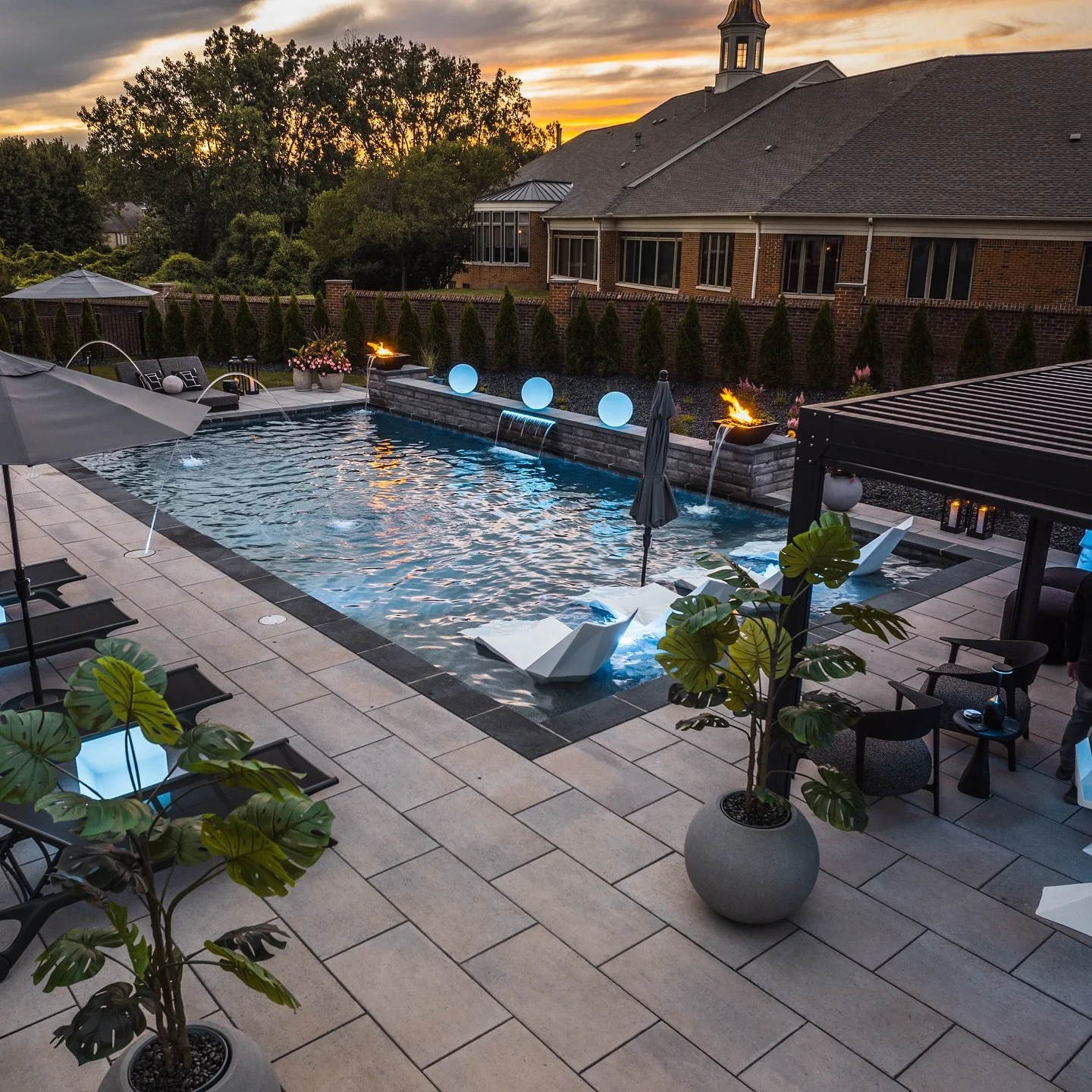 we turned this backyard into a dream oasis ✨🌊🔥 from the sleek pool to the cozy fire bowls and stylish brick pavers, it&rsquo;s the perfect spot for relaxation and outdoor fun. DM us today to build your own oasis too. #BackyardGoals #PoolsideVibes #