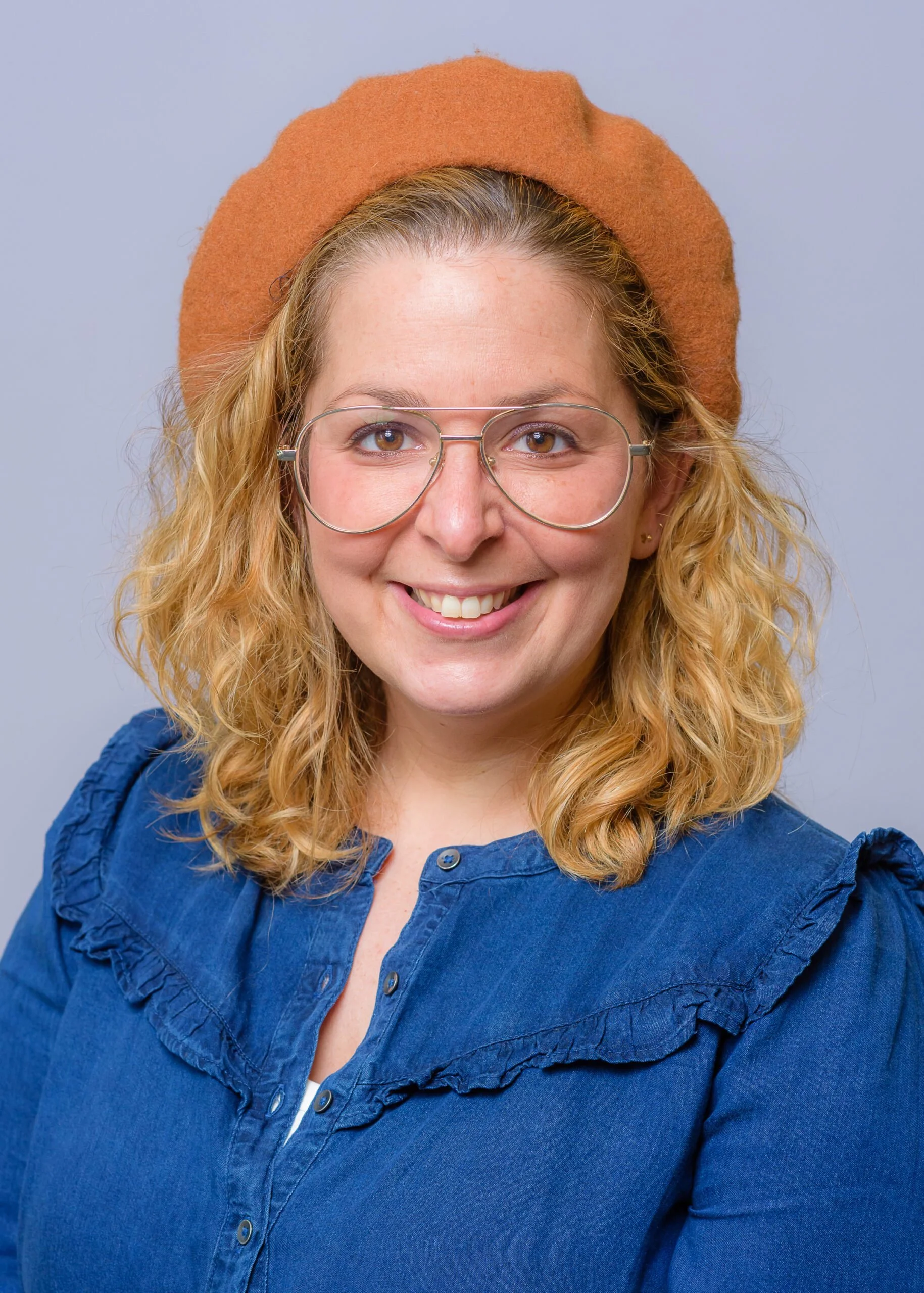 Picture of Shuli Taubes, she has shoulder length light brown hair with clear glasses and a yellow sweater