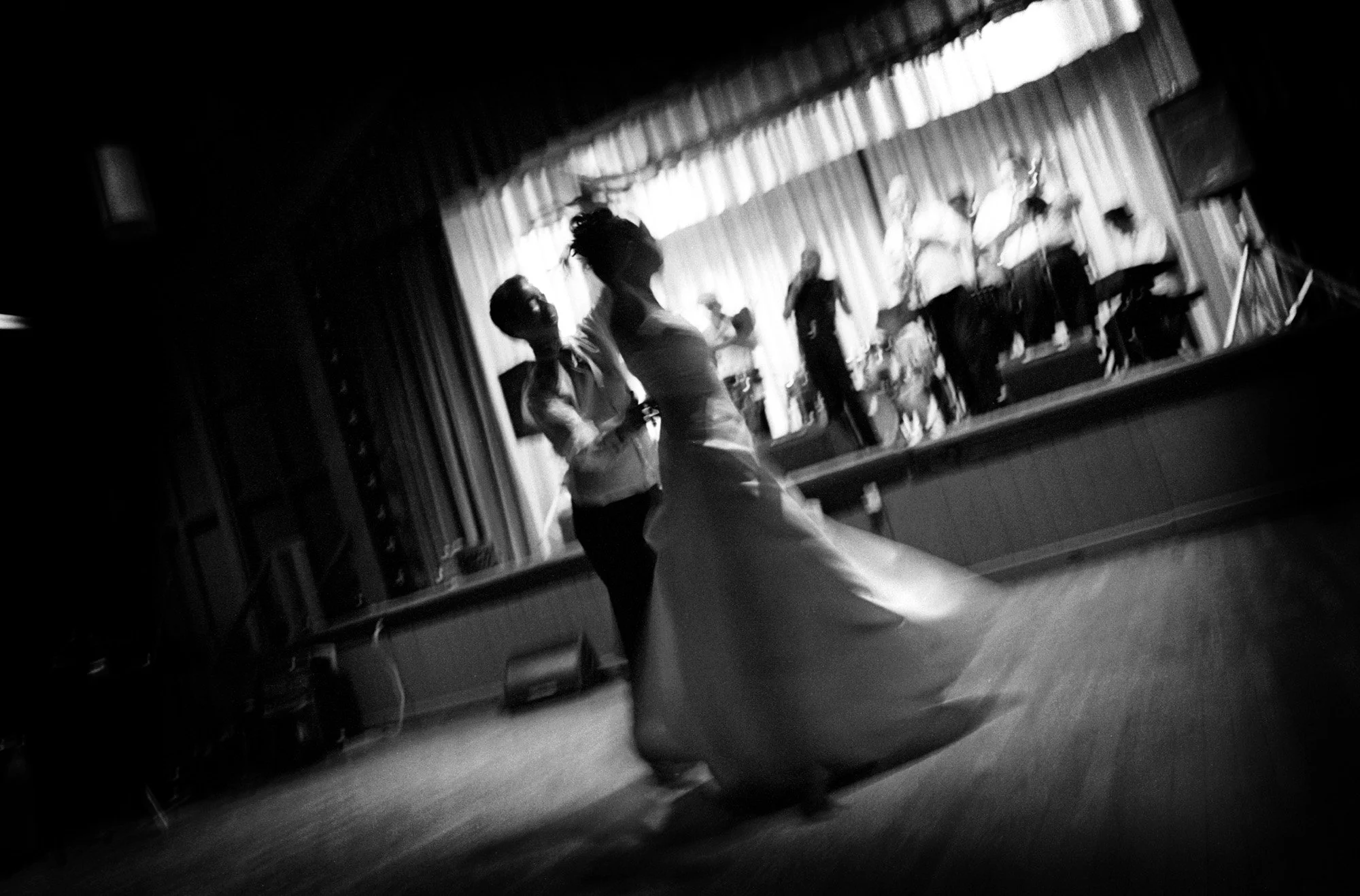 Newlyweds moving across the dance floor during their first dance.