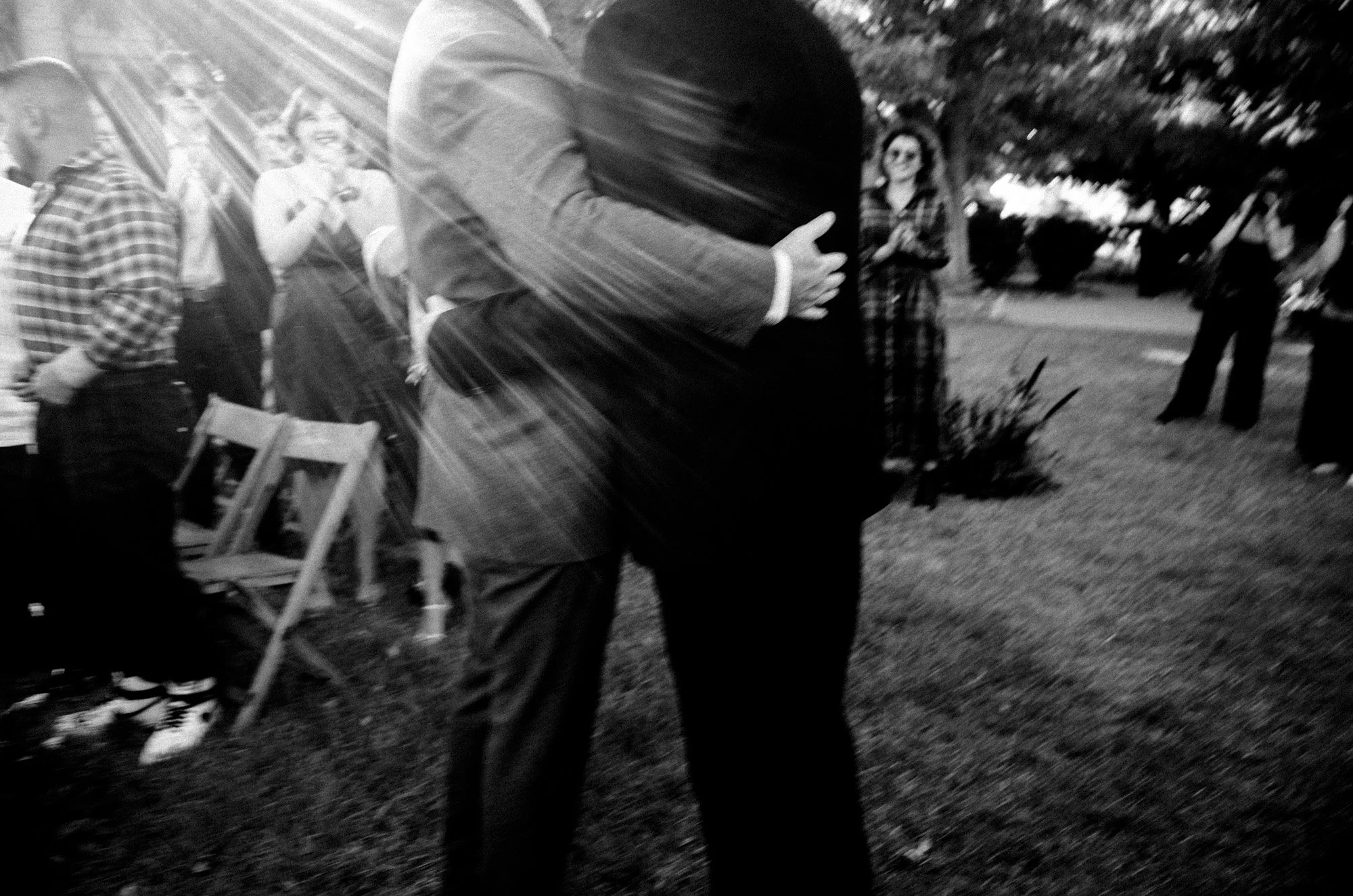 Grooms caught in a joyful embrace with motion blur.