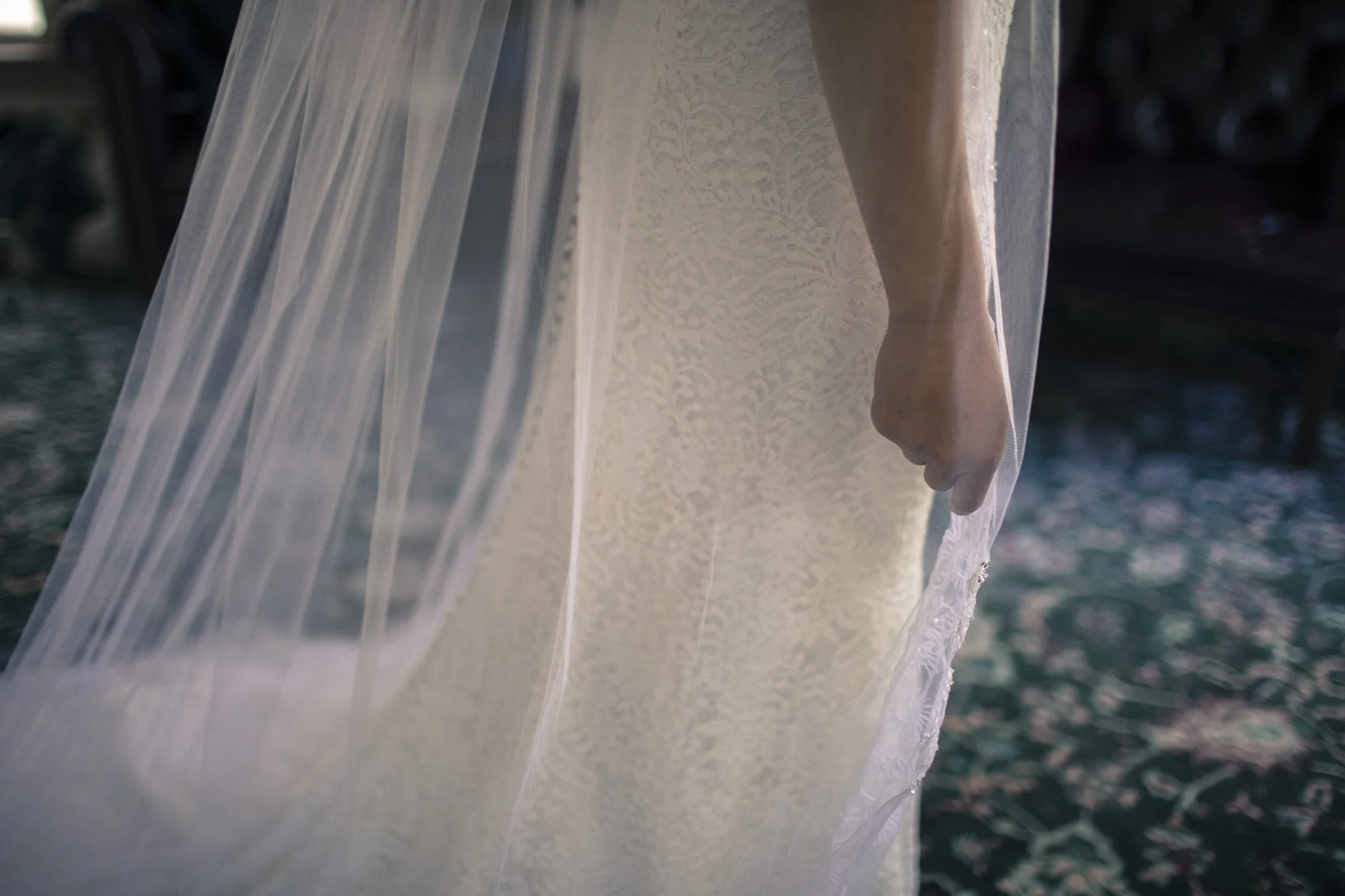 Close-up of the bride’s veil falling over the back of her dress.